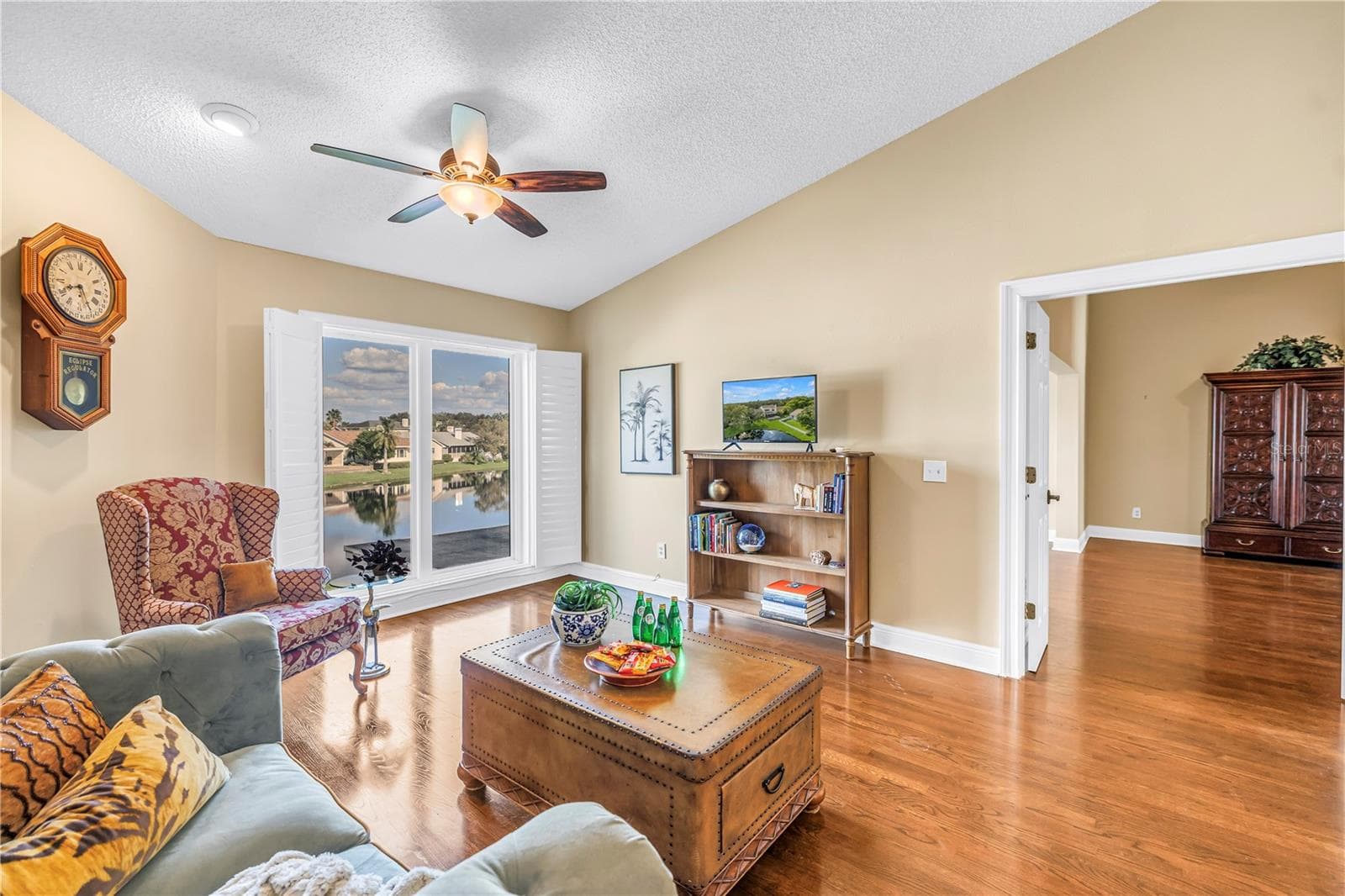 This unique upstairs bonus living space in Caya Costa features vaulted ceilings and premium hardwood flooring. The room offers expansive views of the lake through floor-to-ceiling hurricane-rated windows. - 868 GLADES CT NE, ST PETERSBURG
