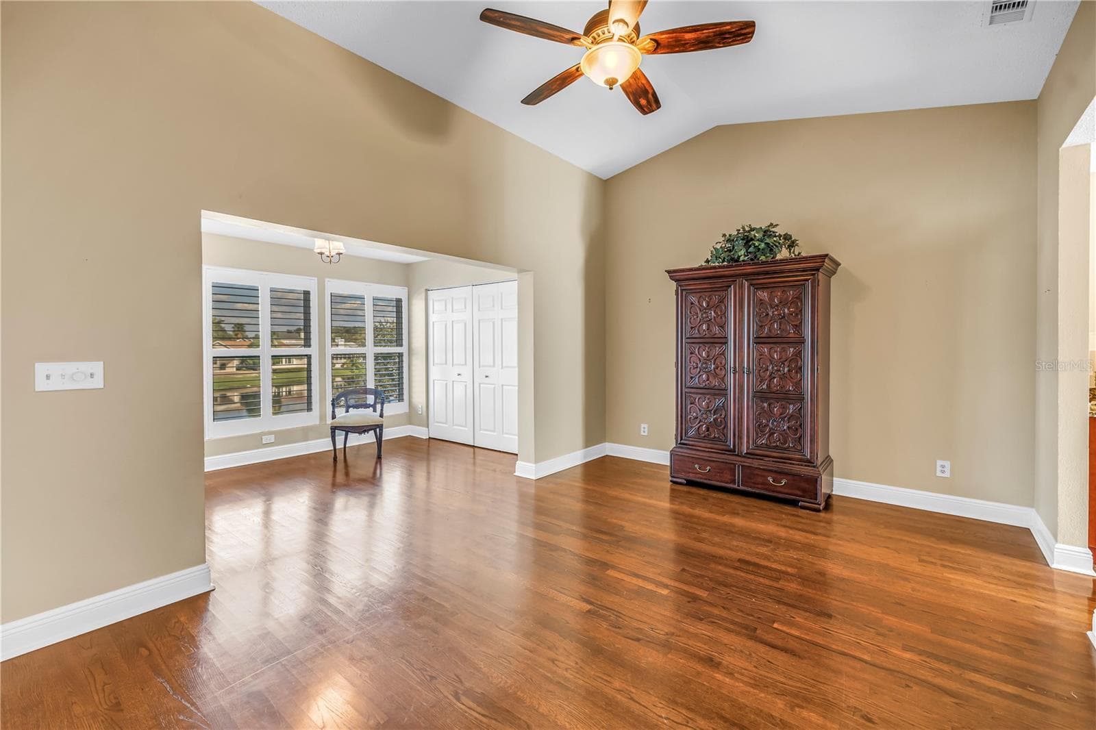 Spacious primary bedroom featuring vaulted ceilings and an elegantly enclosed porch with two additional closets. This room offers magnificent lake views and provides an ideal space for a home gym, a quiet reading nook, or a nursery. - 868 GLADES CT NE, ST PETERSBURG