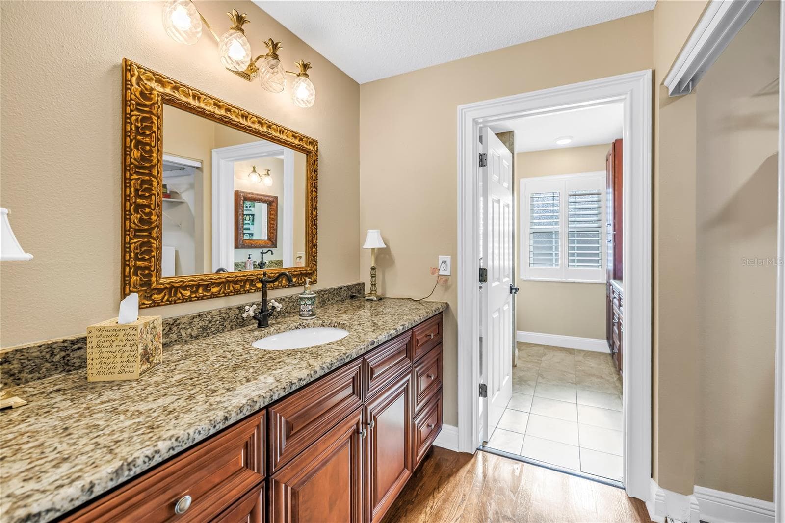 The primary bathroom features high-quality custom solid wood cabinetry, granite countertops, and elegant lighting and bath fixtures. - 868 GLADES CT NE, ST PETERSBURG