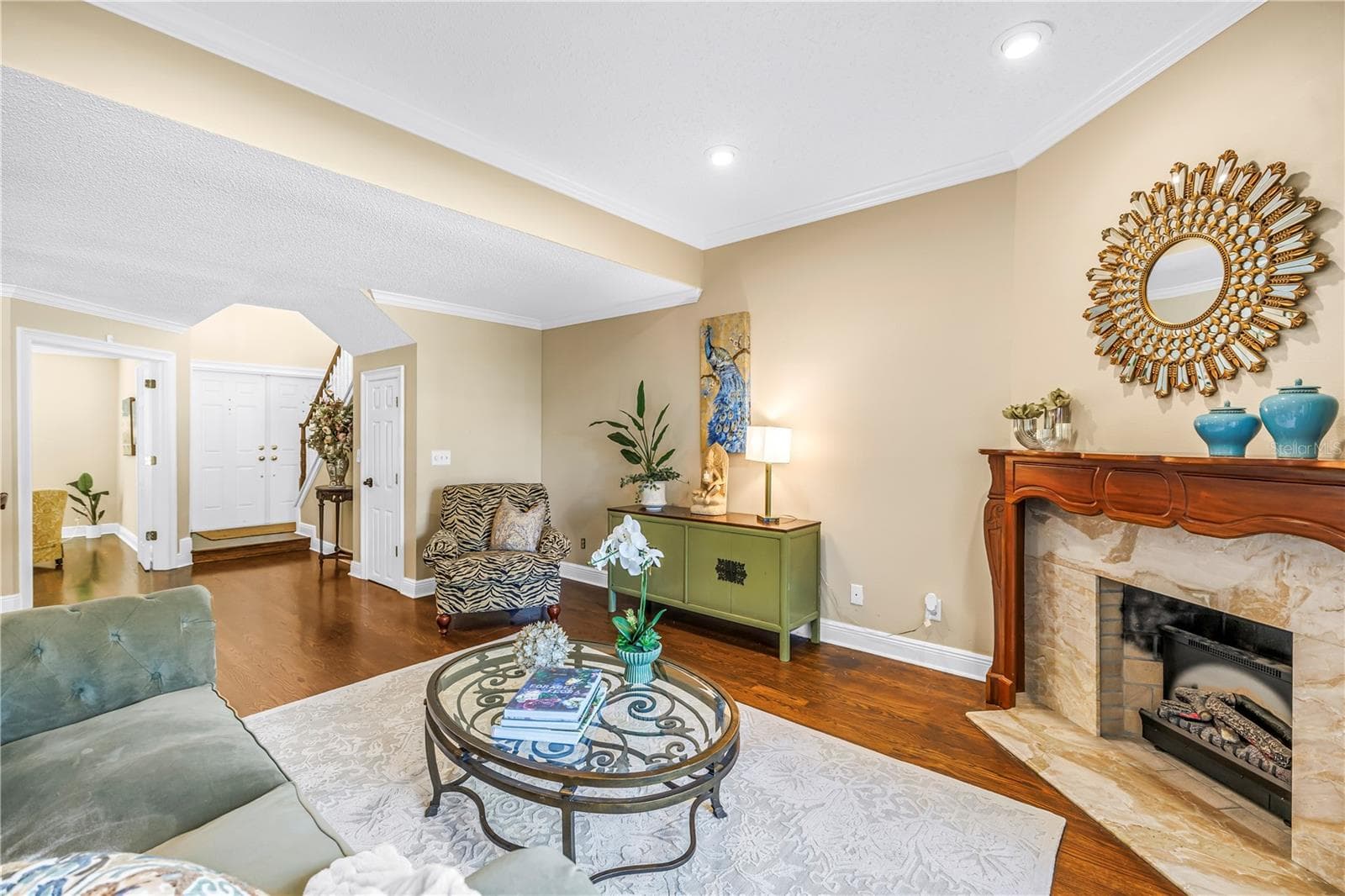 The open formal living area provides an ideal entry for guests, featuring panoramic lake views and an elegant marble fireplace. - 868 GLADES CT NE, ST PETERSBURG