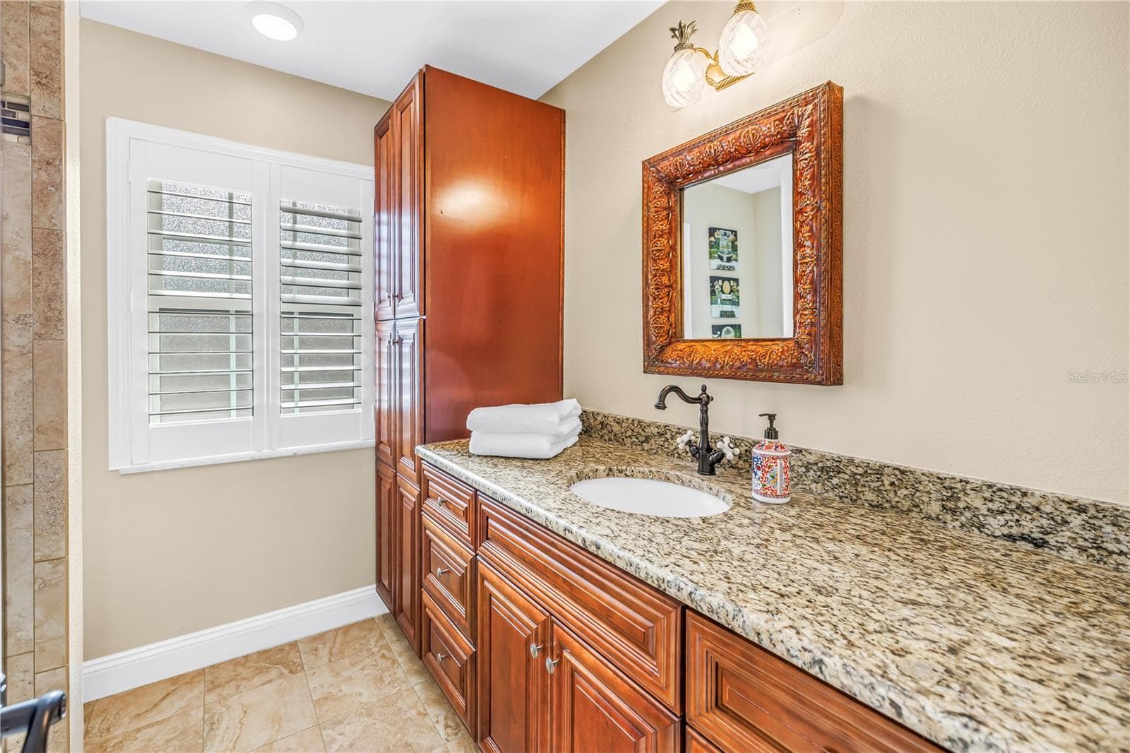 Primary bathroom featuring a second granite vanity, ample storage cabinetry, and custom-built fixtures. - 868 GLADES CT NE, ST PETERSBURG