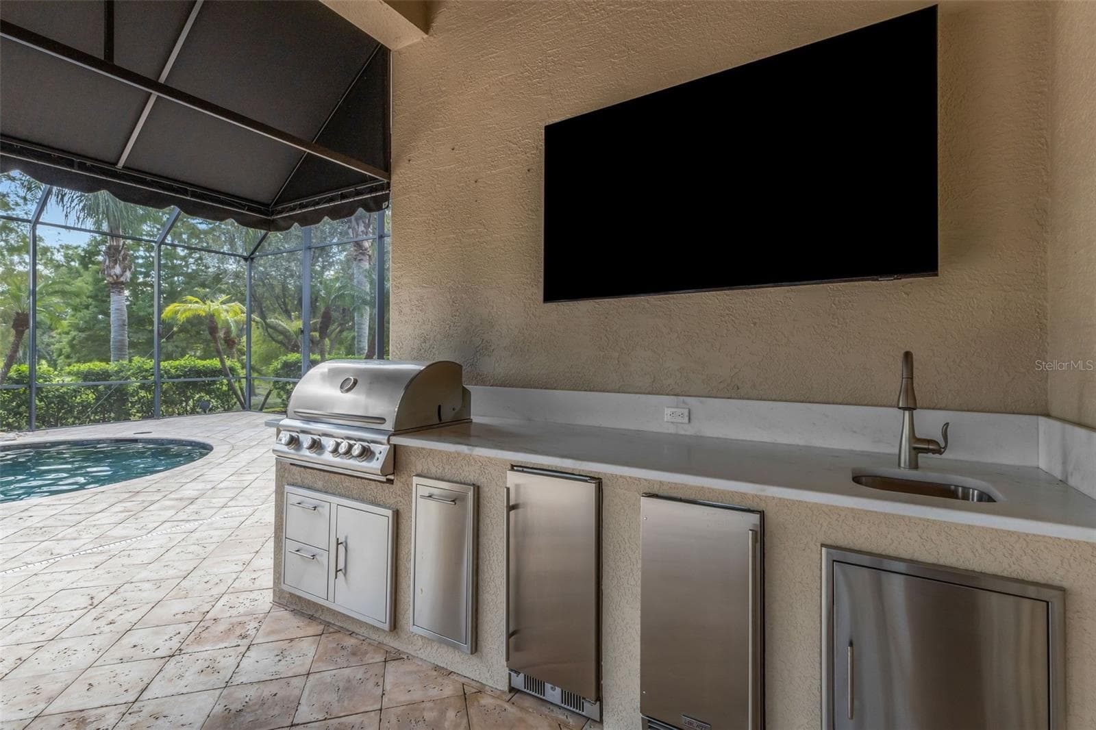 Where you will find a built-in summer kitchen with gas grill, refrigeration units, sink and more! - 2734 BELLERIVE DR, LAKELAND