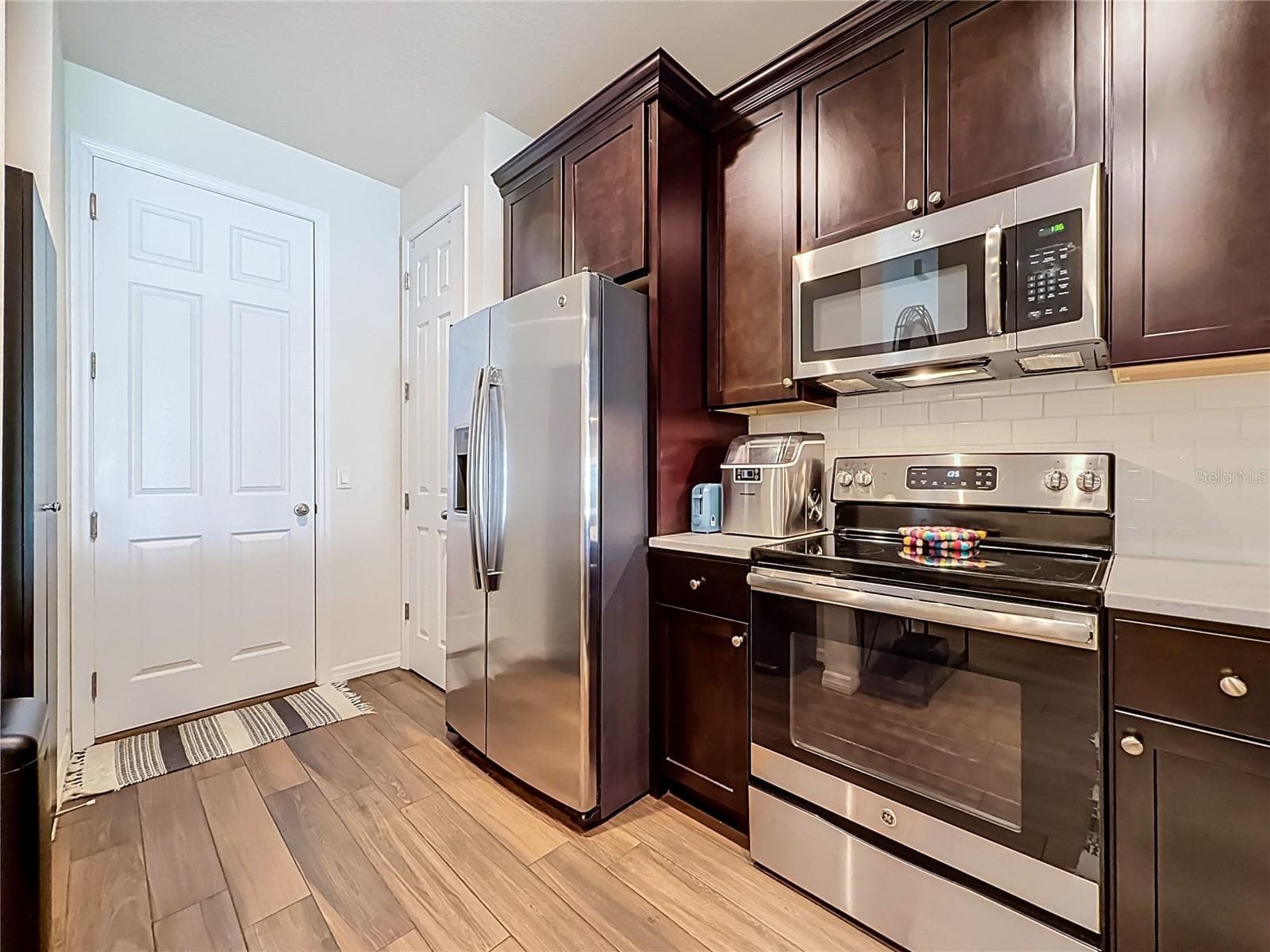 The well-appointed kitchen offers SOLID WOOD CABINETRY, GRANITE countertops, stainless steel appliances, a breakfast bar, and ample storage. - 2270 MONTVIEW DR, CLEARWATER