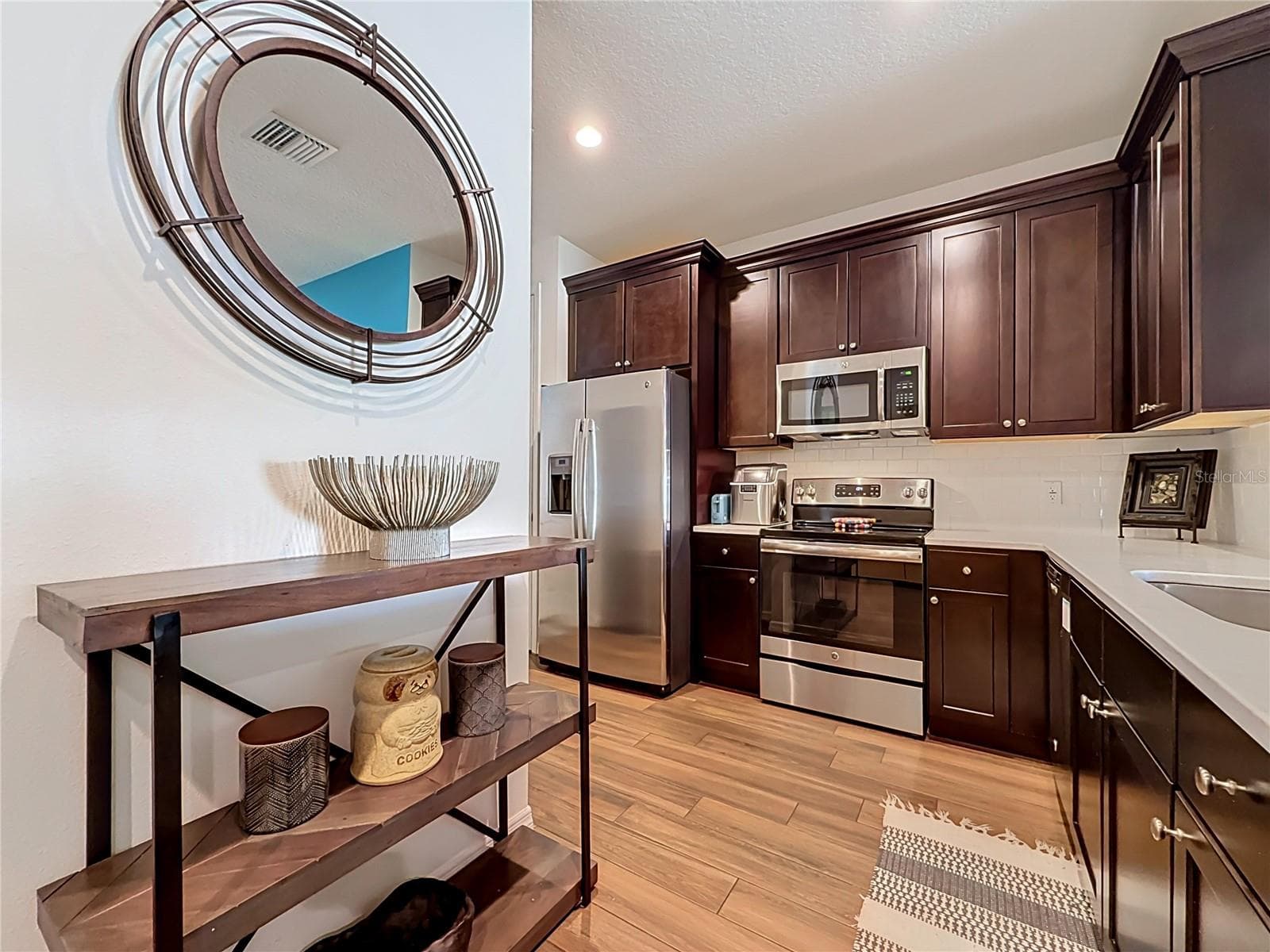 The well-appointed kitchen offers SOLID WOOD CABINETRY, GRANITE countertops, stainless steel appliances, a breakfast bar, and ample storage. - 2270 MONTVIEW DR, CLEARWATER