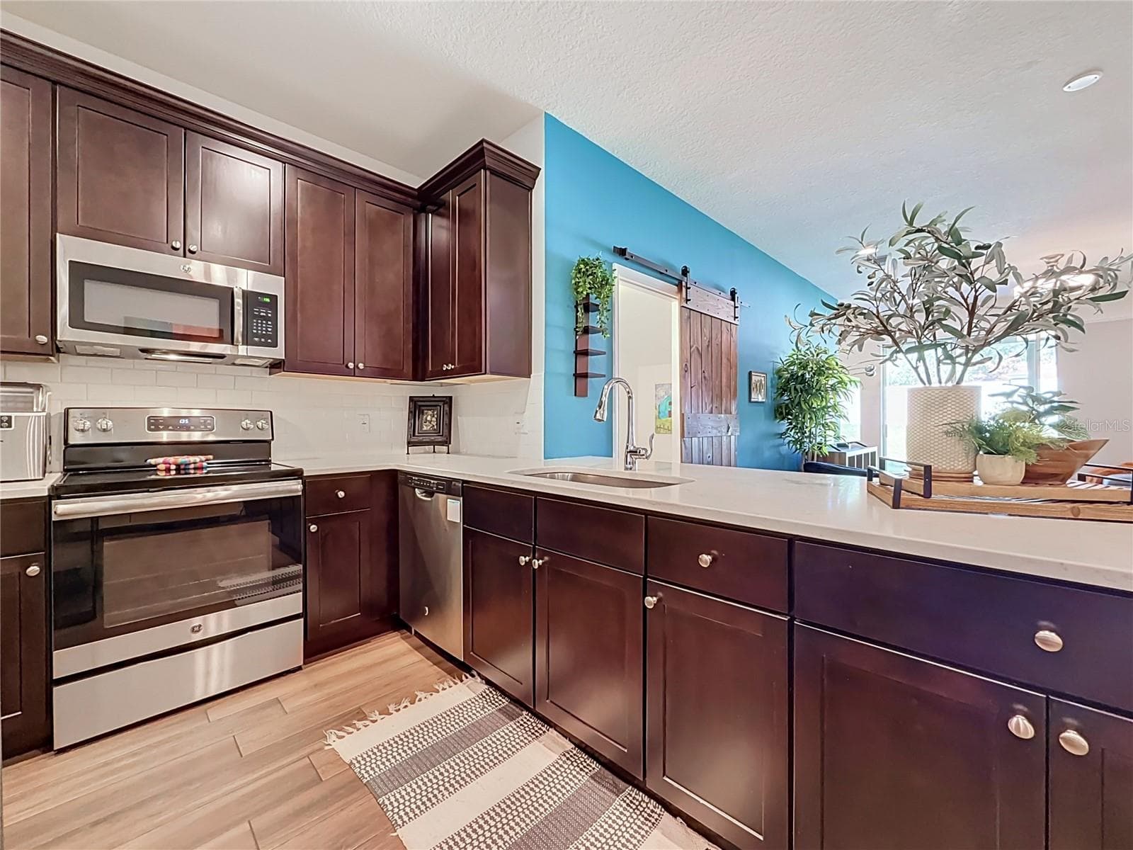 The well-appointed kitchen offers SOLID WOOD CABINETRY, GRANITE countertops, stainless steel appliances, a breakfast bar, and ample storage. - 2270 MONTVIEW DR, CLEARWATER