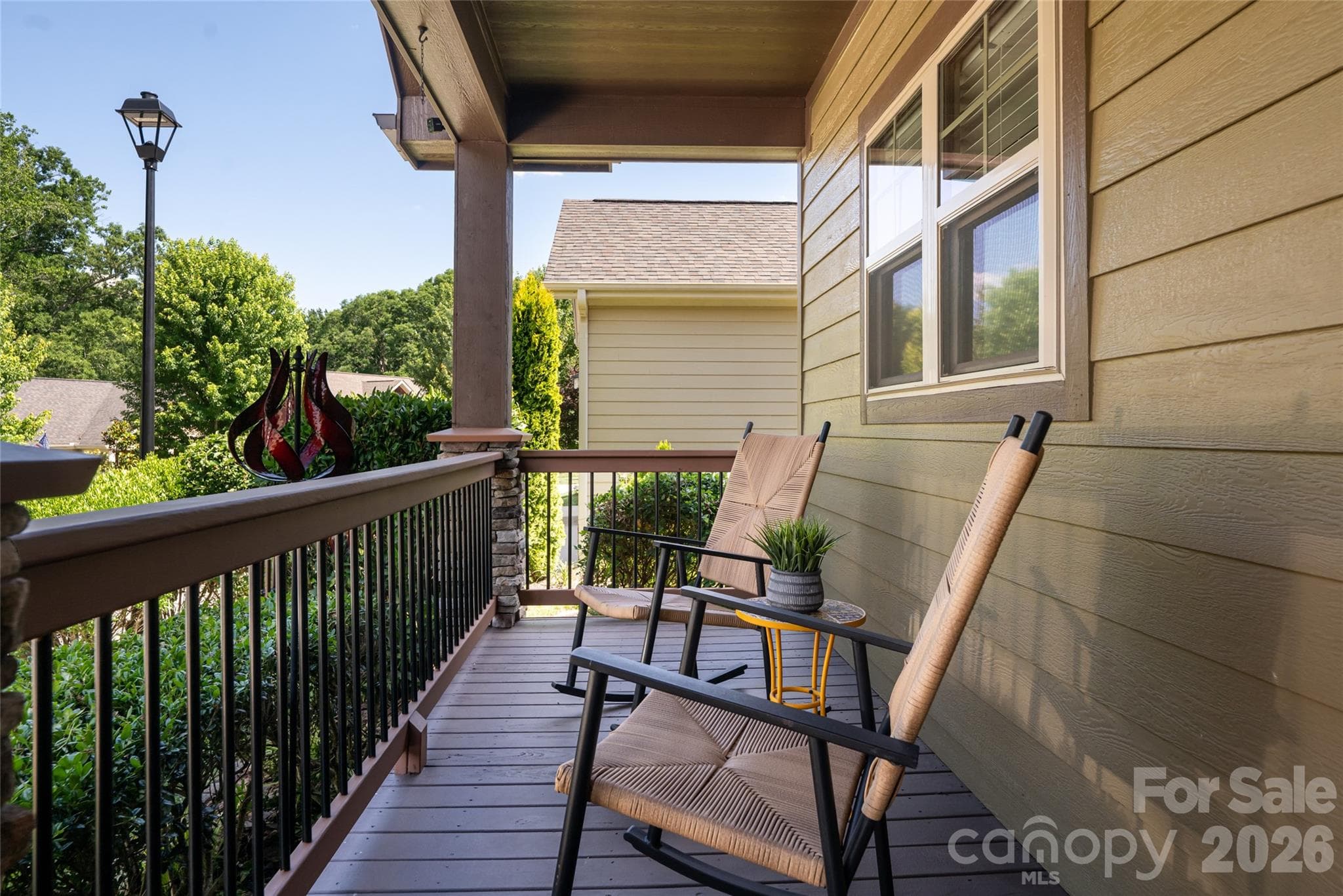Covered front porch with space for rocking chairs, overlooking the community's landscaped streetscape. - 17 Asher Lane, Arden