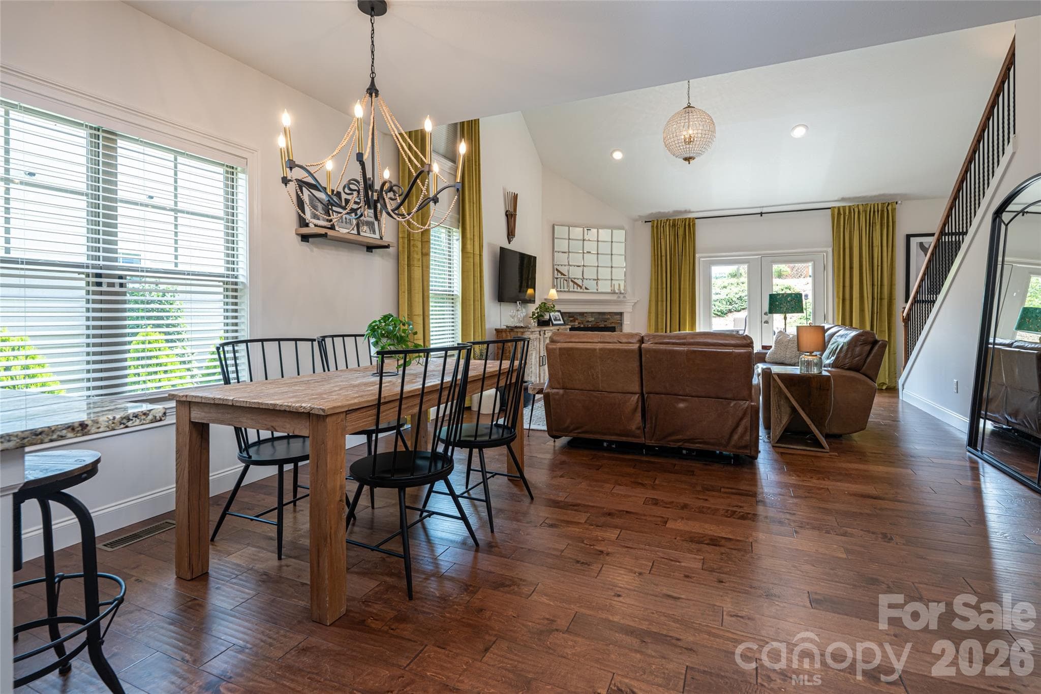 Dining area open to the great room, with wood floors and an iron chandelier. - 17 Asher Lane, Arden