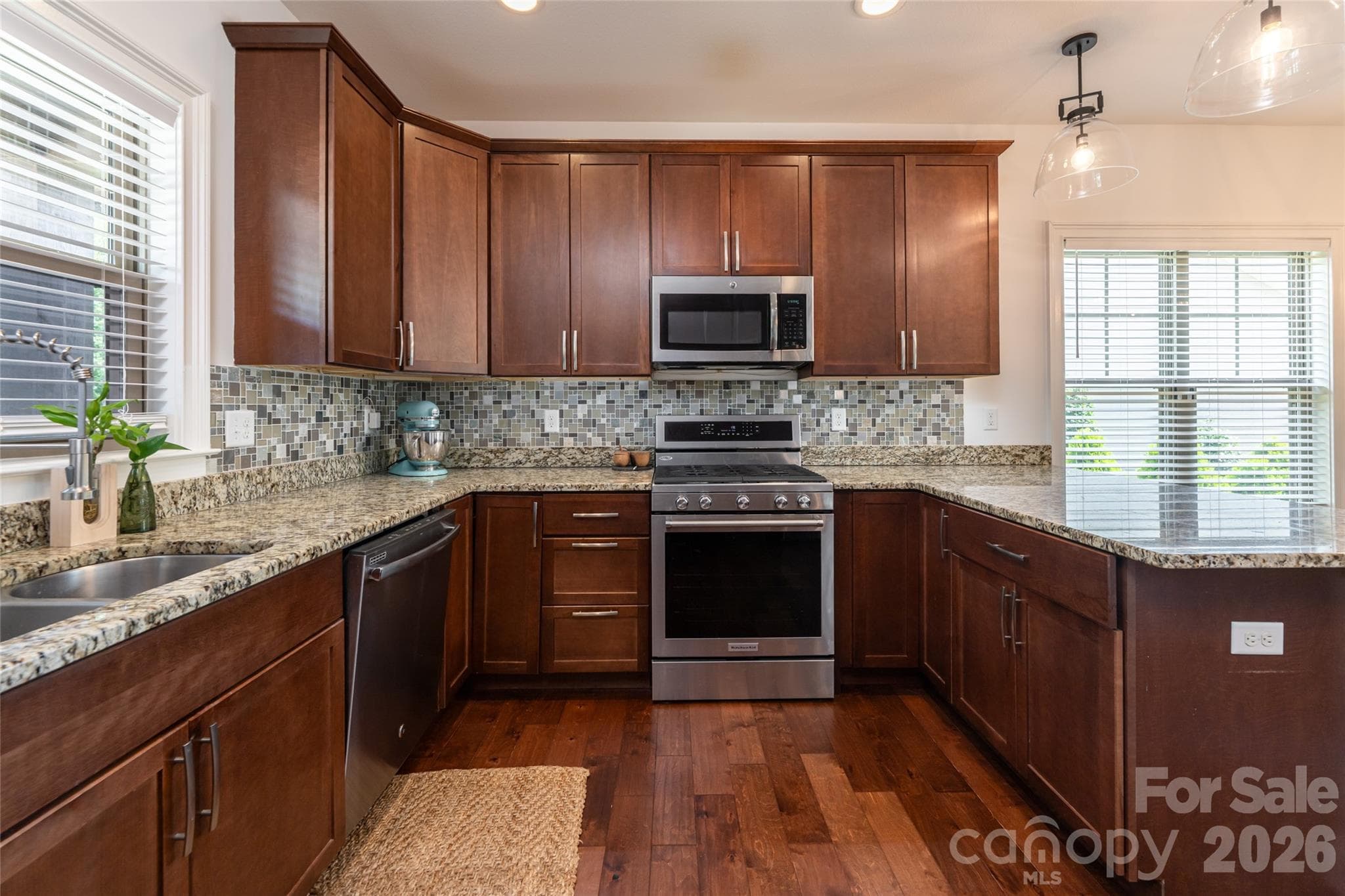Kitchen range wall with stainless gas range and a window over the prep area. - 17 Asher Lane, Arden