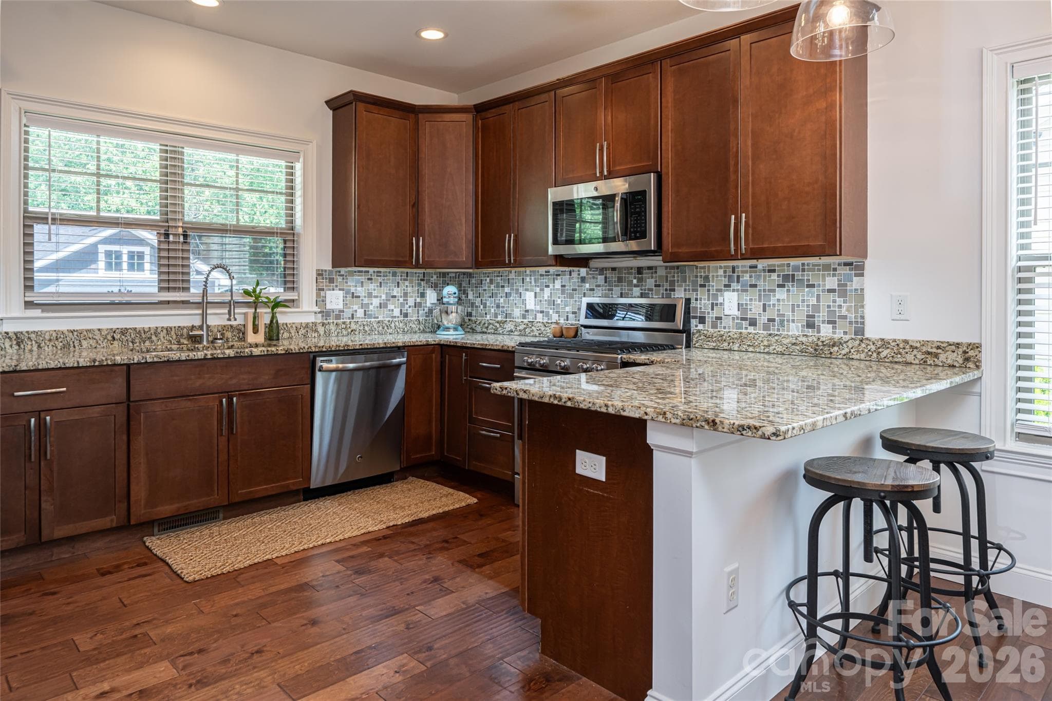 Kitchen with rich wood cabinetry, granite countertops, stainless steel microwave and dishwasher. - 17 Asher Lane, Arden