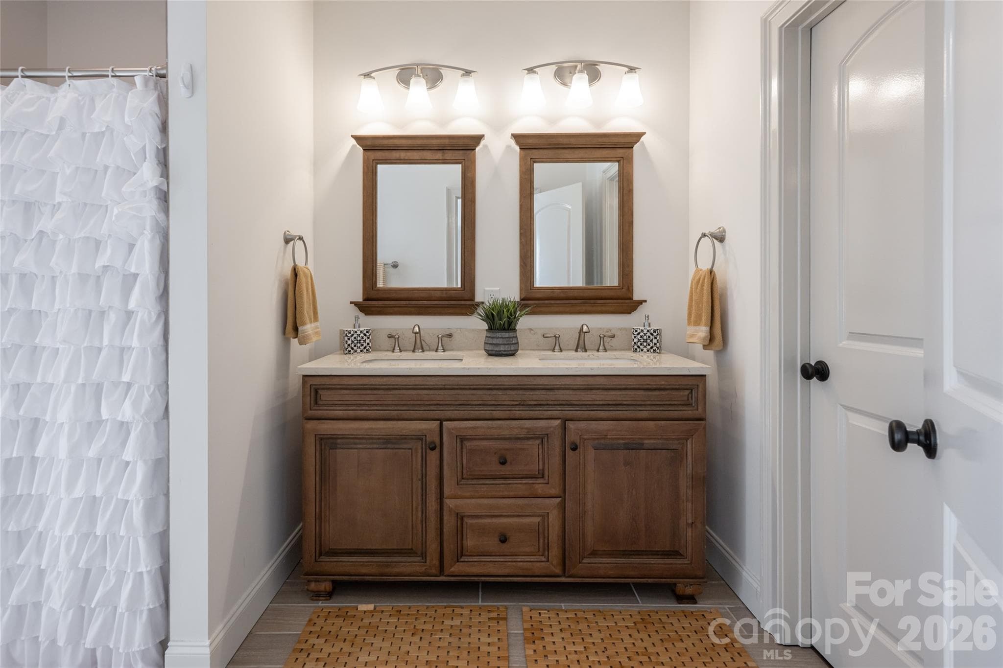 Primary bath with double-sink wood vanity and framed mirrors. - 17 Asher Lane, Arden