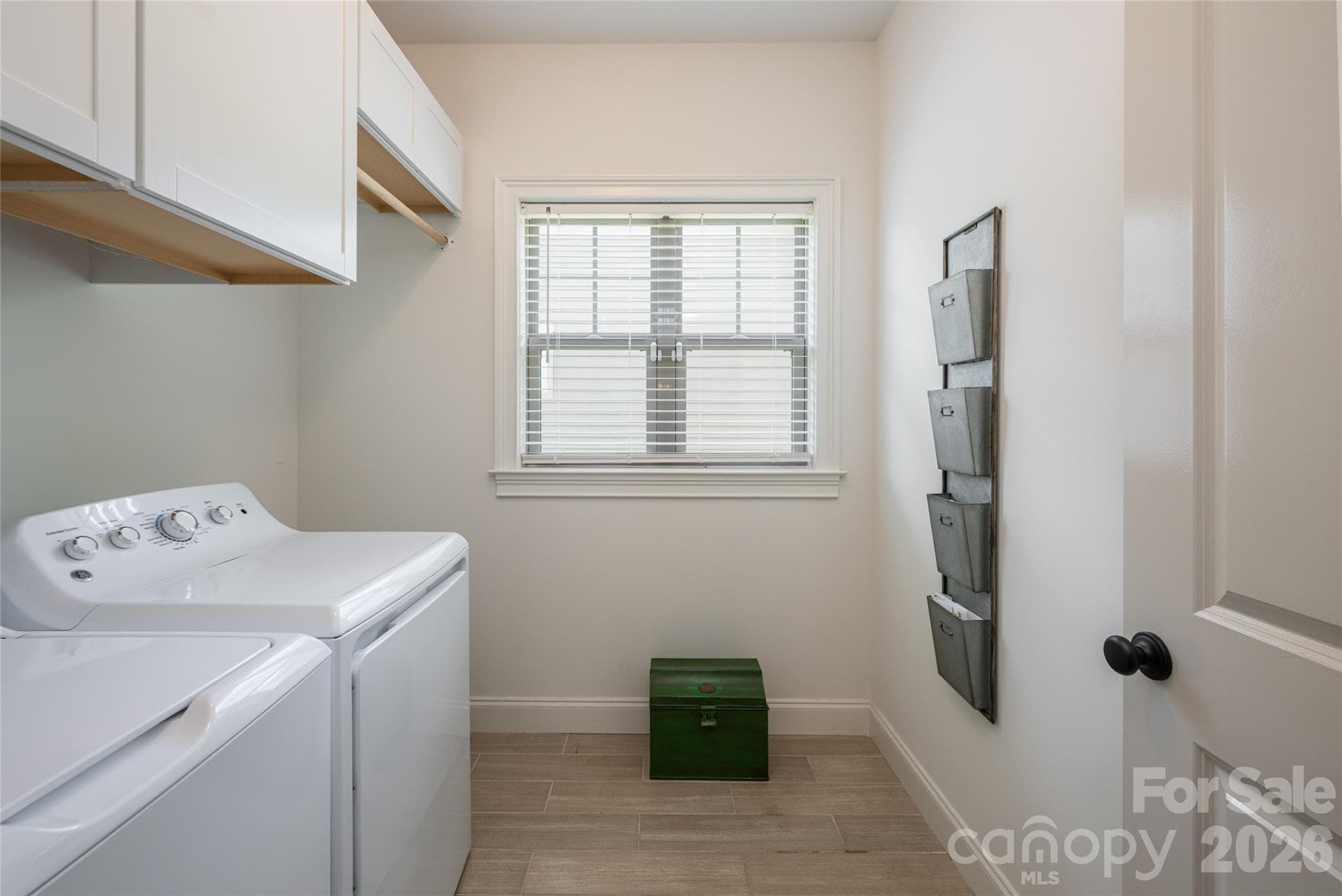 Main-level laundry room with washer, dryer, storage, and natural light. - 17 Asher Lane, Arden
