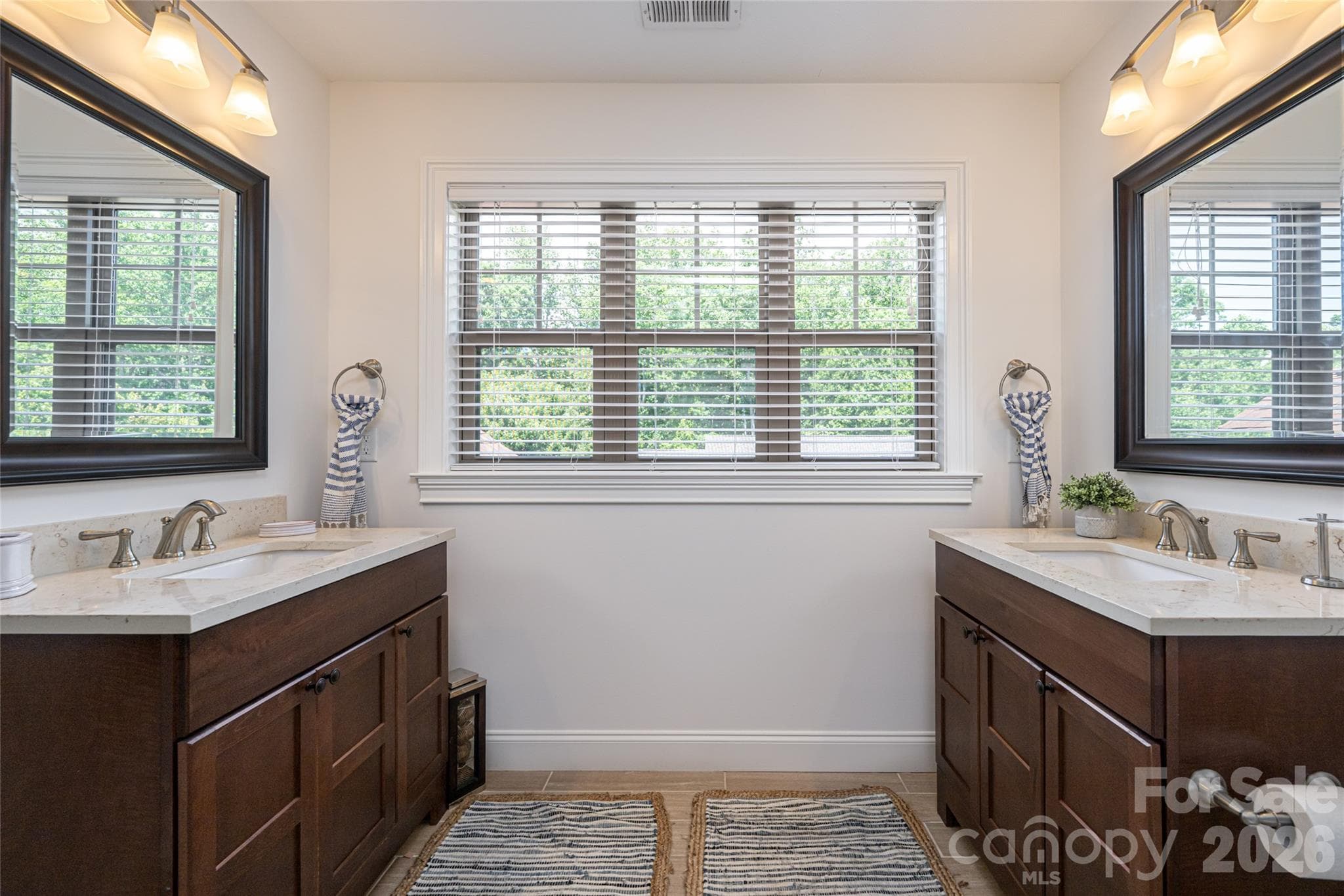 Upper-level full bath with double-sink vanity beneath a wide window with plantation shutters. - 17 Asher Lane, Arden