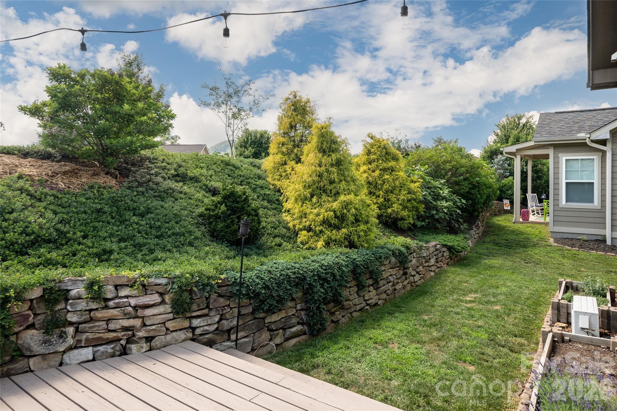 Terraced stone retaining walls with mature evergreen and specimen plantings. - 17 Asher Lane, Arden