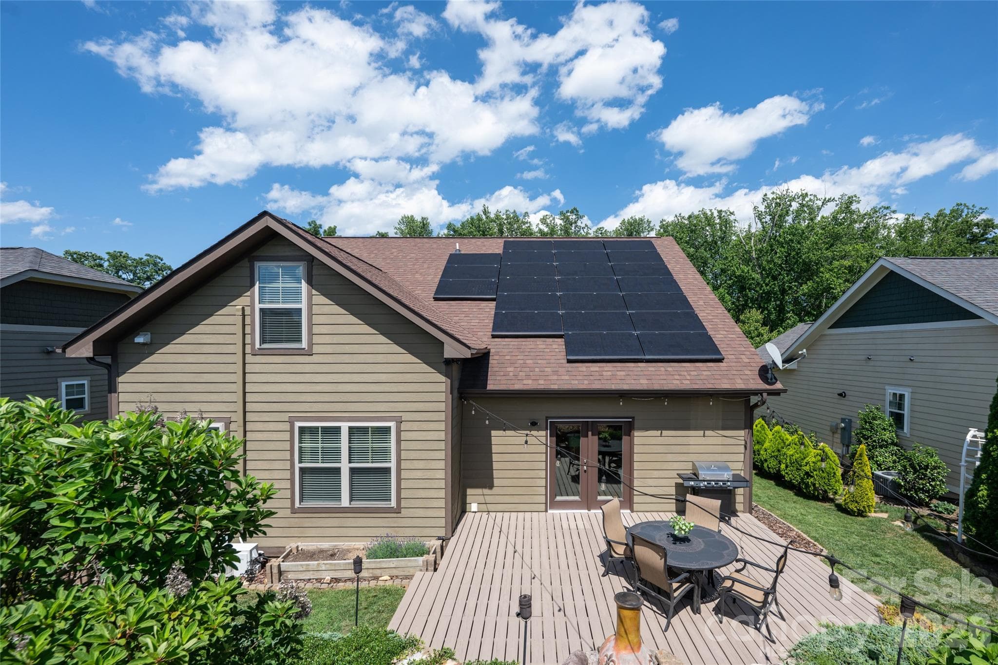 Aerial view of the deck, patio, and landscaped yard, with the paid-off solar panels visible. - 17 Asher Lane, Arden
