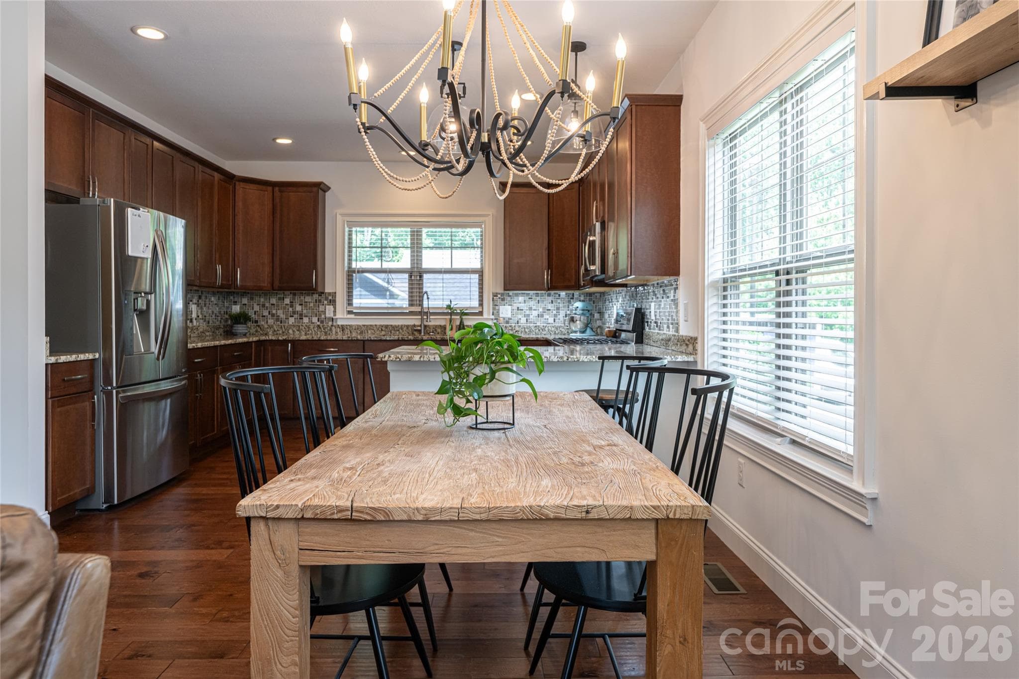 Granite kitchen island with breakfast bar seating beneath an iron chandelier. - 17 Asher Lane, Arden