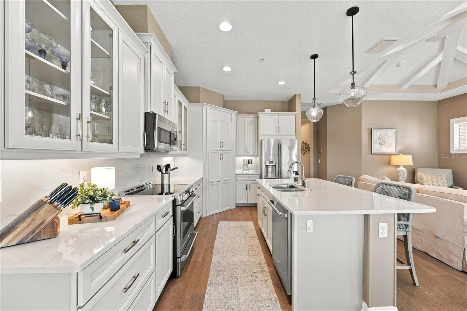 The well-designed kitchen shines with GE Café stainless steel appliances, elegant quartz countertops, and a spacious walk-in pantry. - 291 COMPASS POINT DR #201, BRADENTON