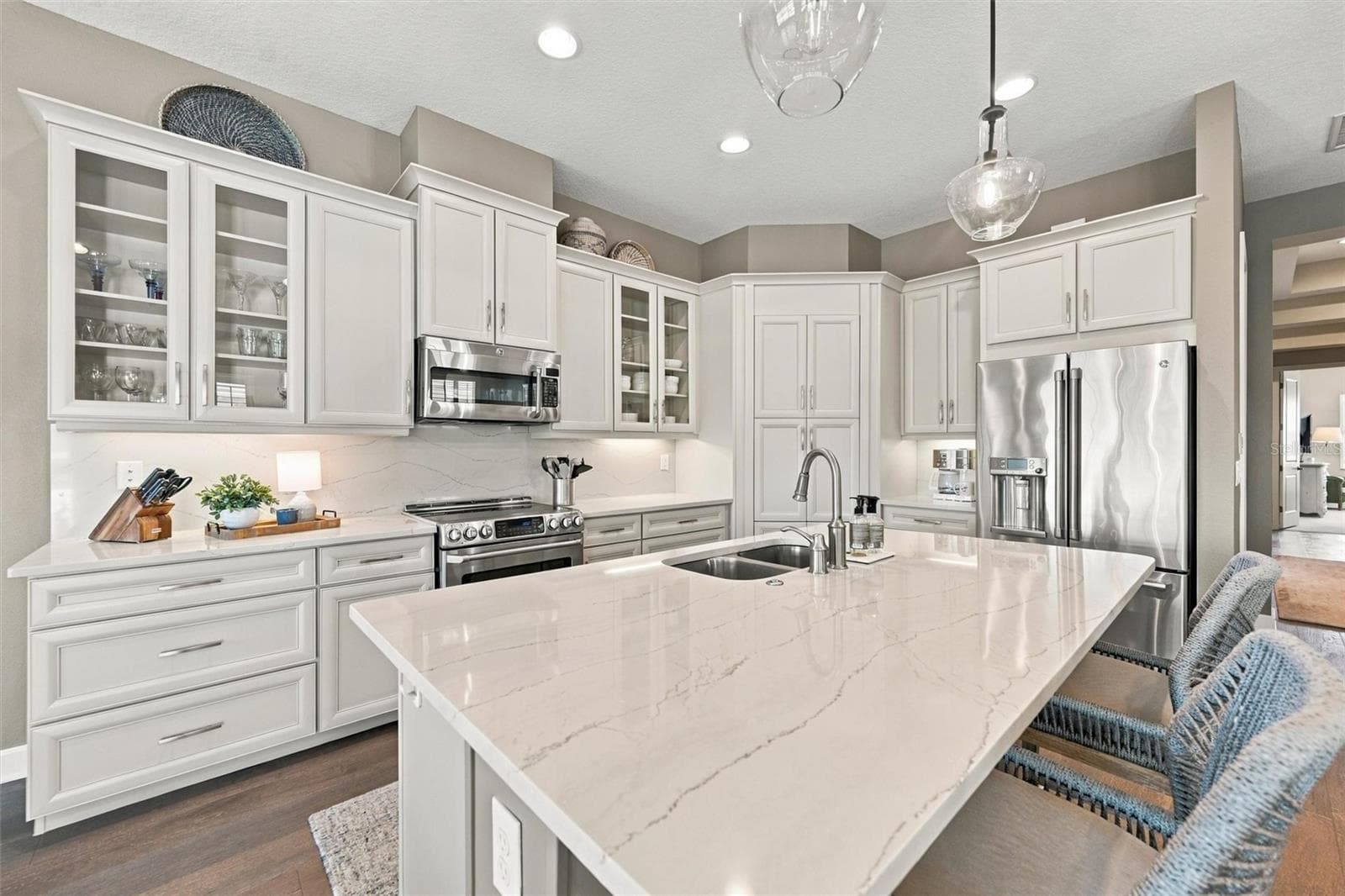 The well-designed kitchen shines with GE Café stainless steel appliances, elegant quartz countertops, and a spacious walk-in pantry. - 291 COMPASS POINT DR #201, BRADENTON