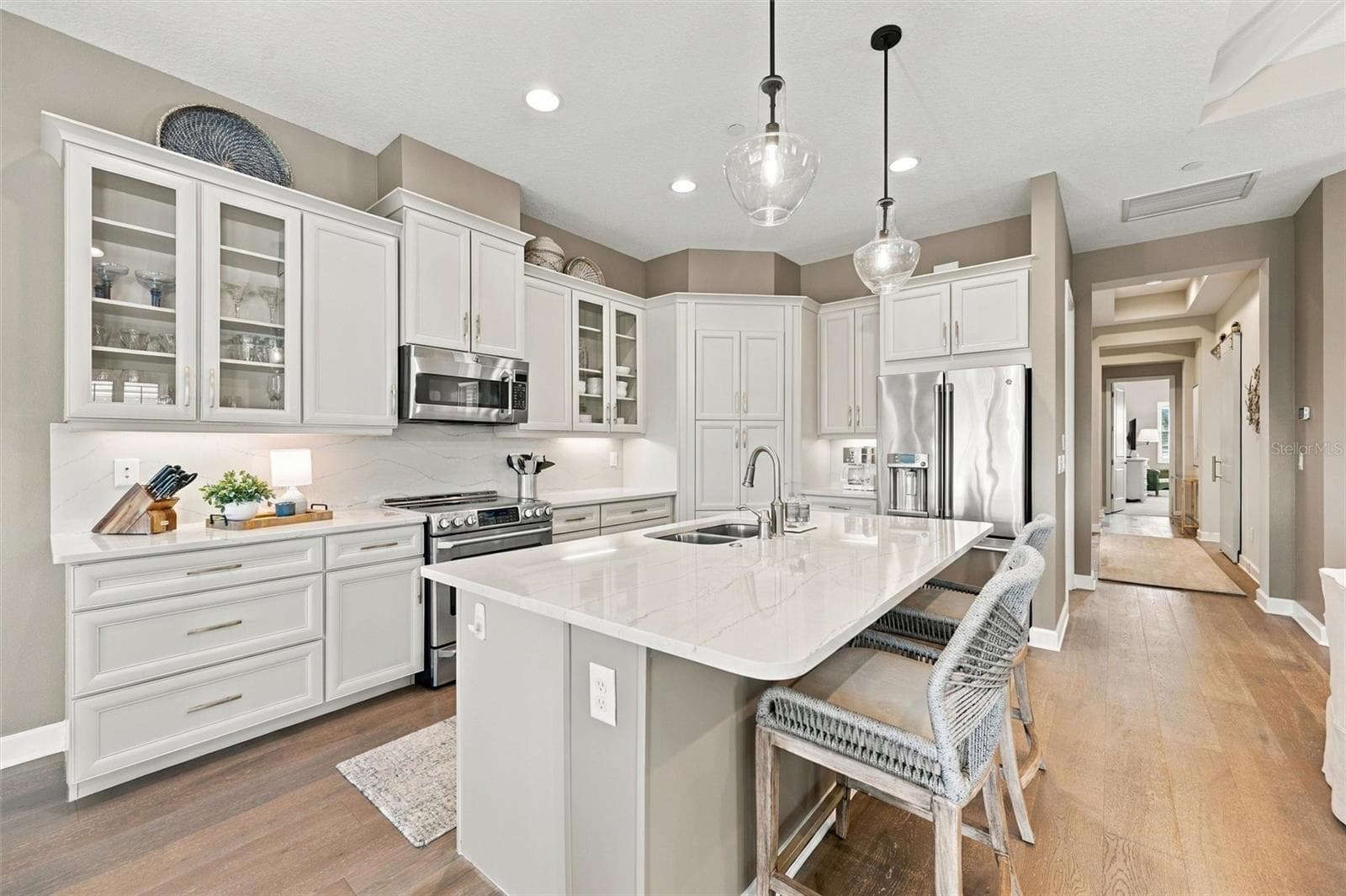 The well-designed kitchen shines with GE Café stainless steel appliances, elegant quartz countertops, and a spacious walk-in pantry. - 291 COMPASS POINT DR #201, BRADENTON