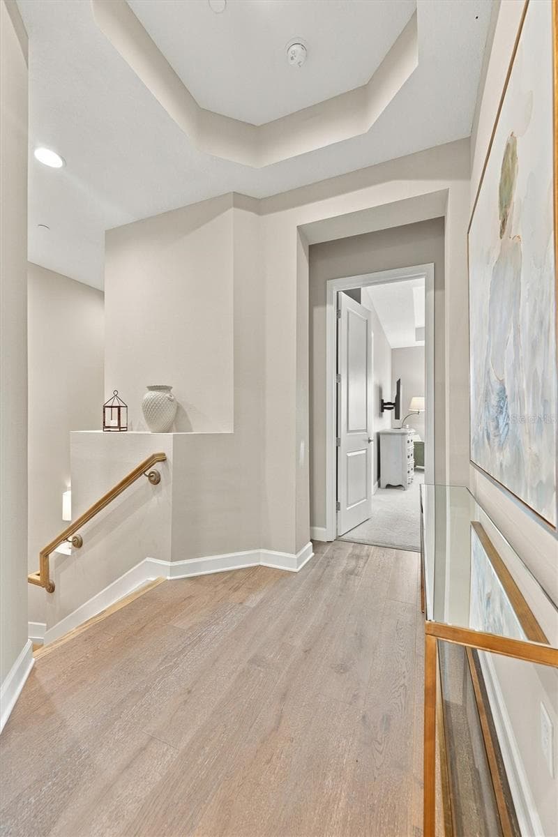 Hallway up the stairs that leads to the Primary Bedroom, 2nd Bedroom and Elevator. - 291 COMPASS POINT DR #201, BRADENTON