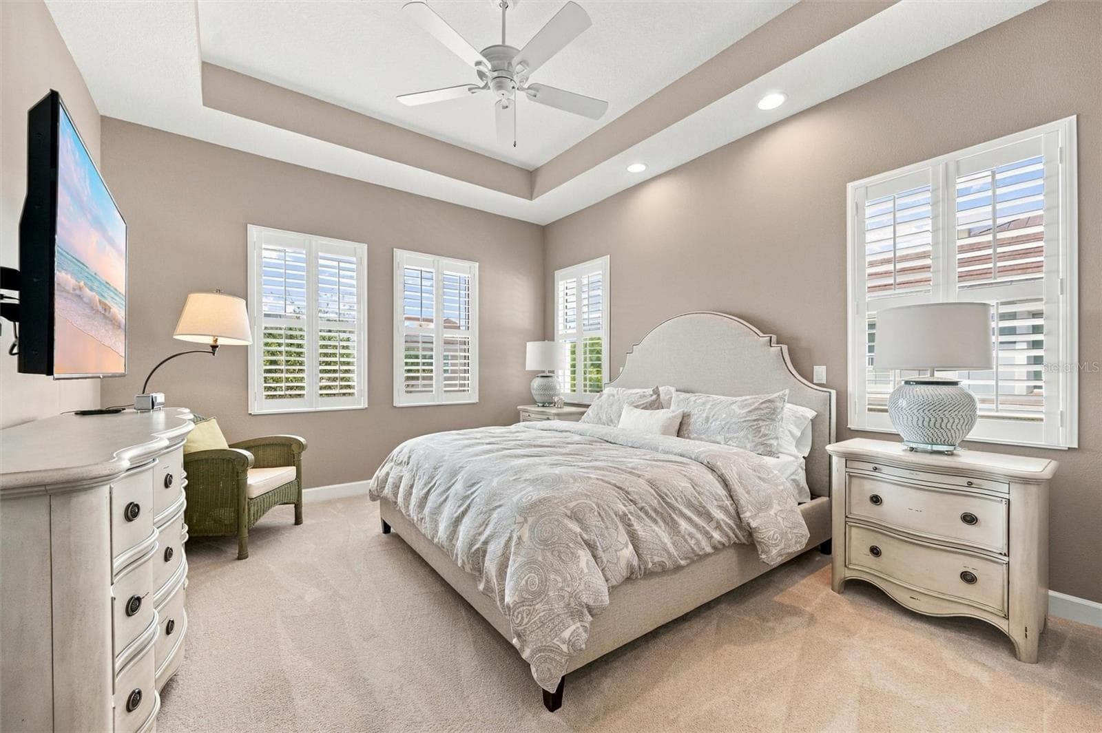 Spacious primary suite, featuring an elegant tray ceiling and two walk-in closets for ample storage. - 291 COMPASS POINT DR #201, BRADENTON