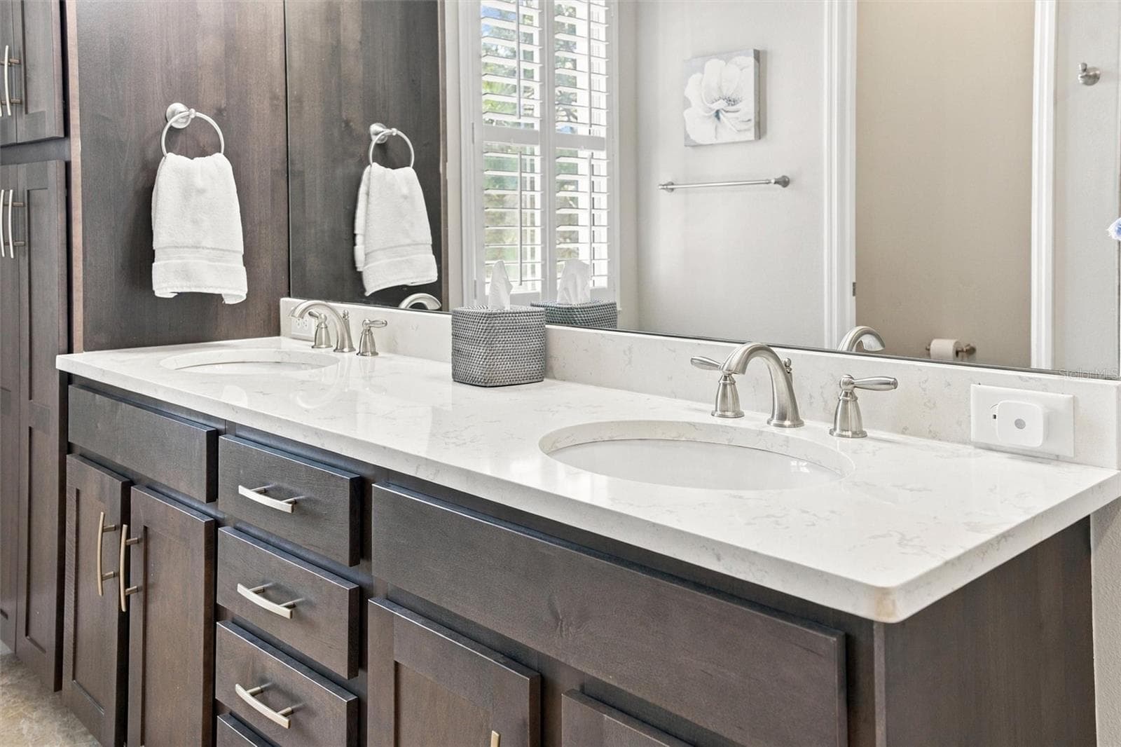 The spacious primary ensuite features dual vanities, a large walk-in shower, a private water closet, and convenient access to one of the suite’s two walk-in closets. - 291 COMPASS POINT DR #201, BRADENTON