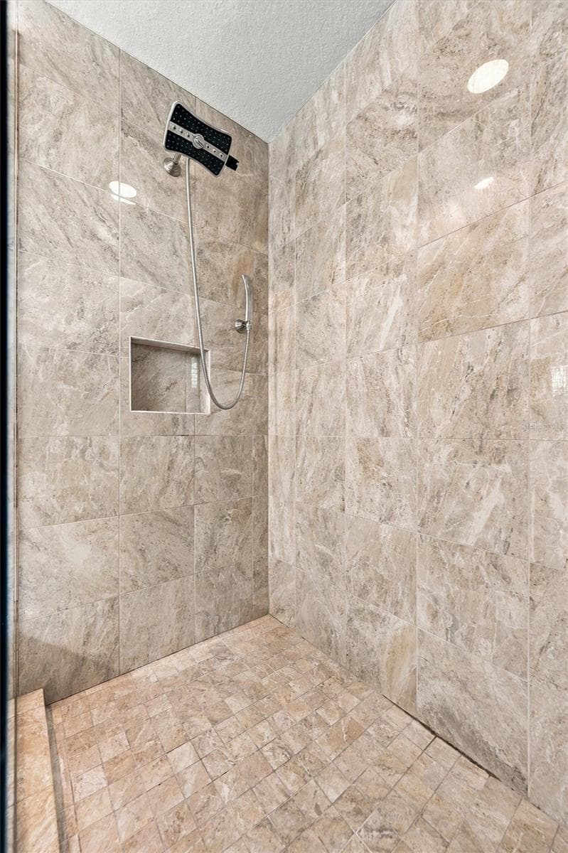 The spacious primary ensuite features dual vanities, a large walk-in shower, a private water closet, and convenient access to one of the suite’s two walk-in closets. - 291 COMPASS POINT DR #201, BRADENTON