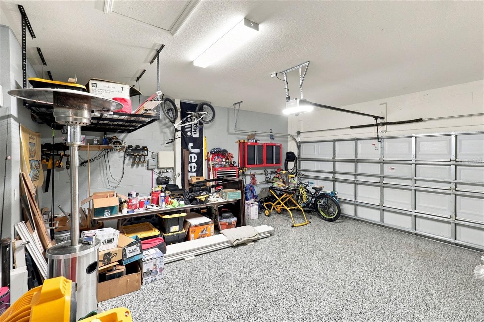 Garage Showcasing Epoxy-Coated Flooring and Ample Storage Space - 33310 MAJOR OAK DR, WESLEY CHAPEL