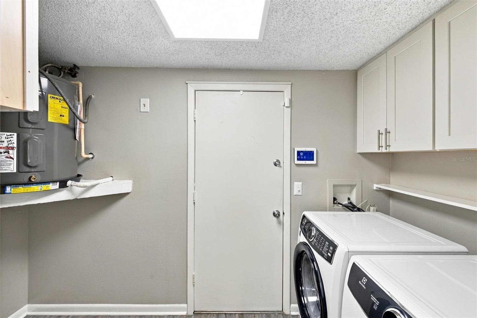 Large laundry room with cabinetry. Door to garage beyond. - 16136 FOXFIRE DR, TAMPA