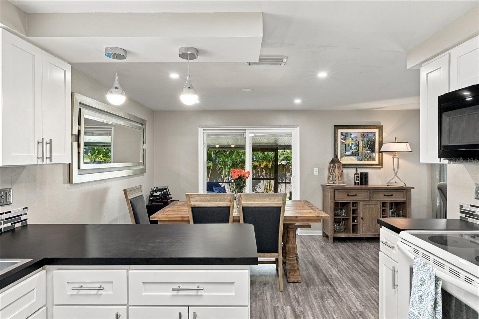 Kitchen to dining room with view of large cov. lanai and lovely backyard. - 16136 FOXFIRE DR, TAMPA