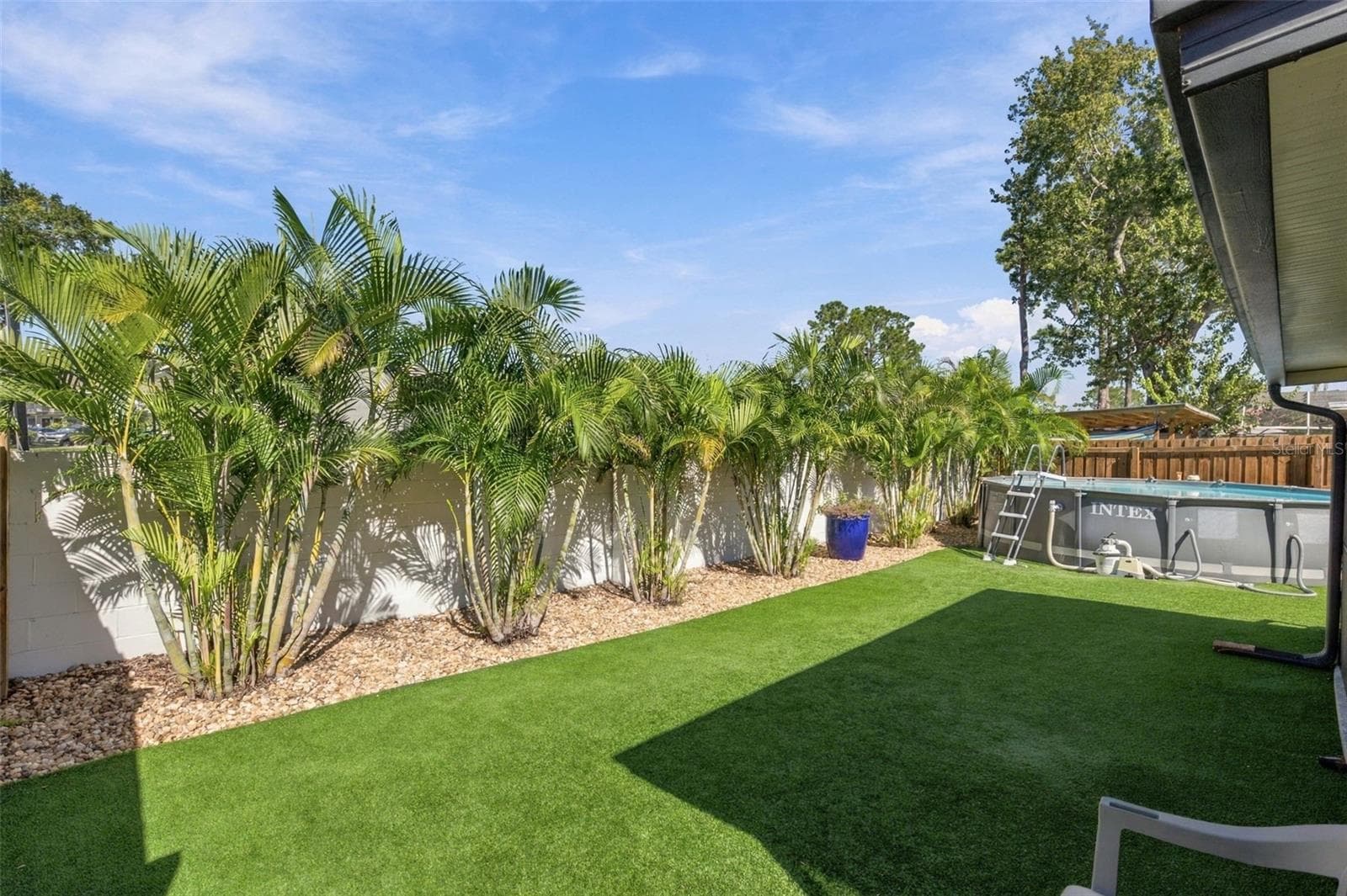 Large backyard with newer above-ground pool, beautiful landscaping and low-maint. artificial turf - 16136 FOXFIRE DR, TAMPA