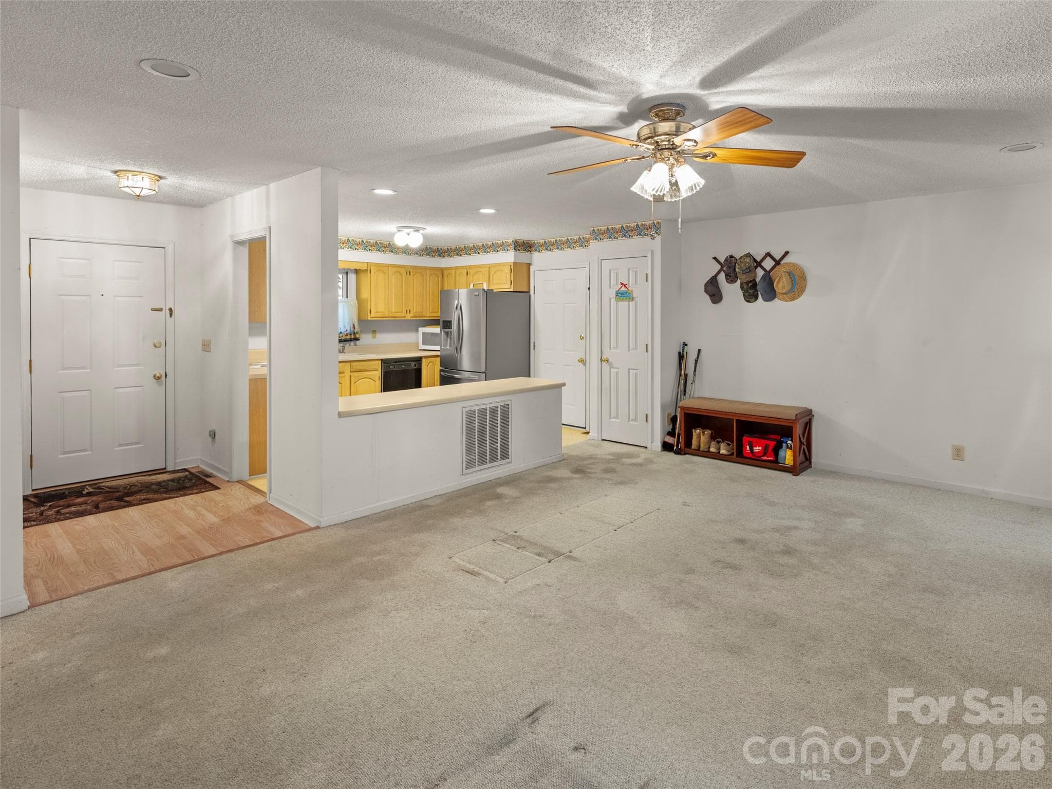 Living room flows into kitchen, with access to garage. - 45 Bearwallow Road, Hendersonville