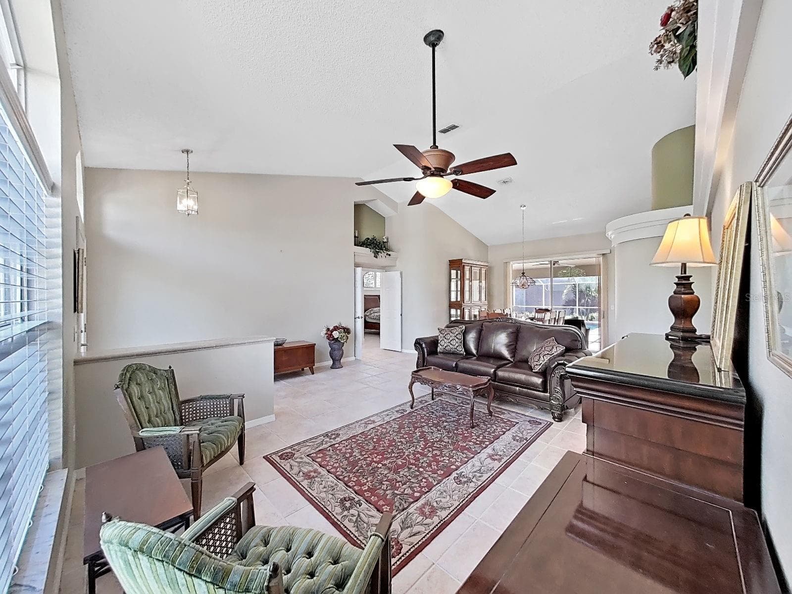 living rm,  note double-door entry to primary bedroom suite, dining room with sliders to pool area and great view of the back yard - 15001 MEADOWLAKE ST, ODESSA