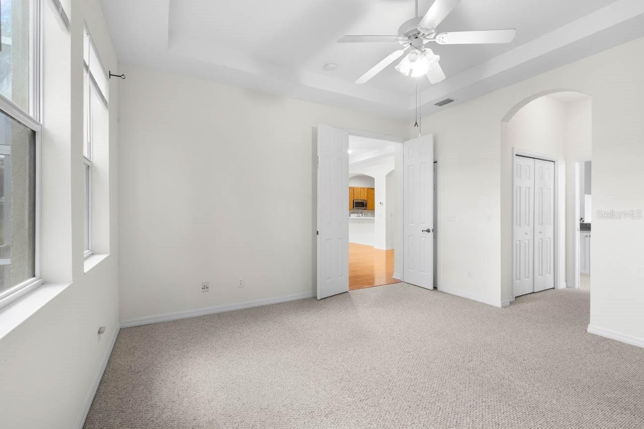 Master bedroom with dual closets leading to the Master bathroom - 1009 CHELSEA GREENS CT #37, SUN CITY CENTER