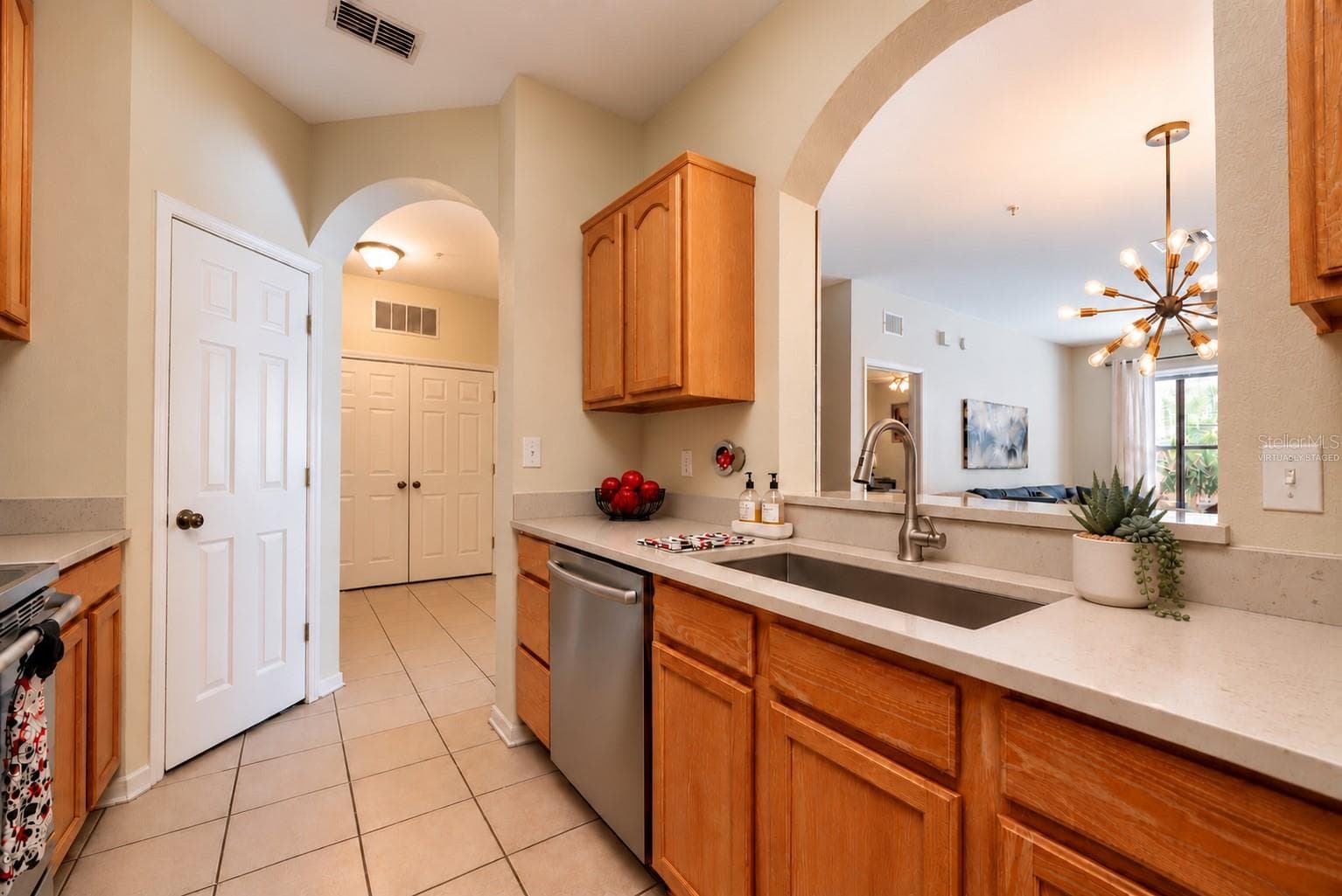 The kitchen opens up to entry and living/dining room open space. <Virtually staged with stainless steel appliances to show the option for buyers> - 2778 ALMATON LOOP #204, KISSIMMEE