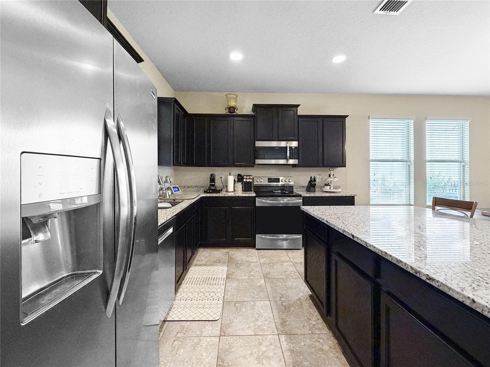 Classic espresso cabinetry, granite counters and stainless appliances - 9662 WATERWAY PASSAGE DR, WINTER GARDEN