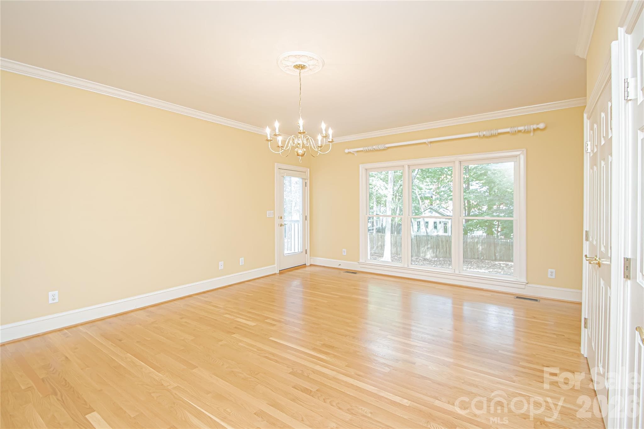 Main level PRIMARY BEDROOM 17'x20'': floor to ceiling windows, door to left is direct access to the back deck and patio. Right wall has two linear closets and a corner ideal for a desk. - 5480 Glen Forest Drive, Charlotte
