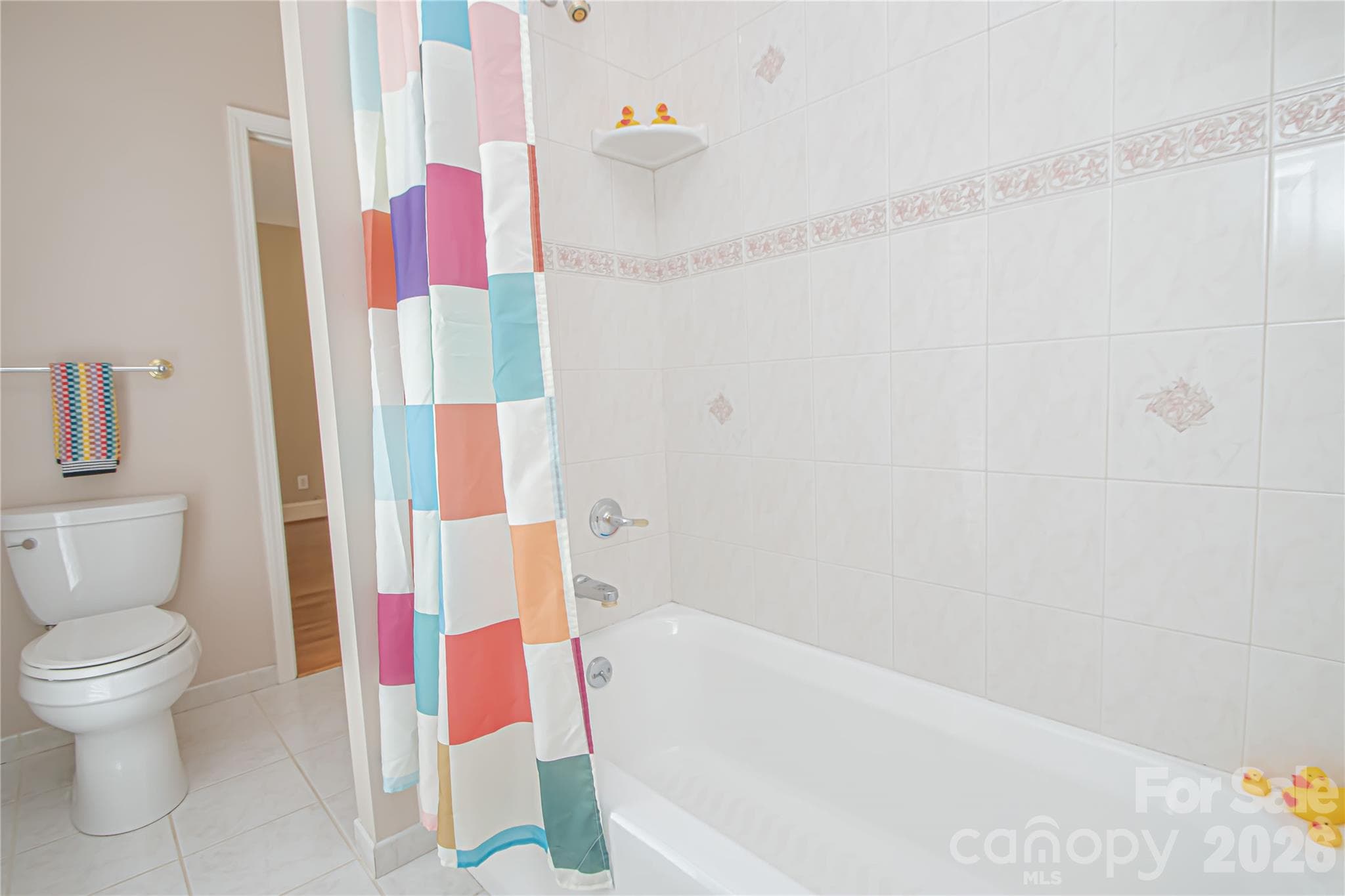 SHARED Bathroom: white tiled floors, tiled shower/tub for bedroom 2 and 3 in main floor. - 5480 Glen Forest Drive, Charlotte