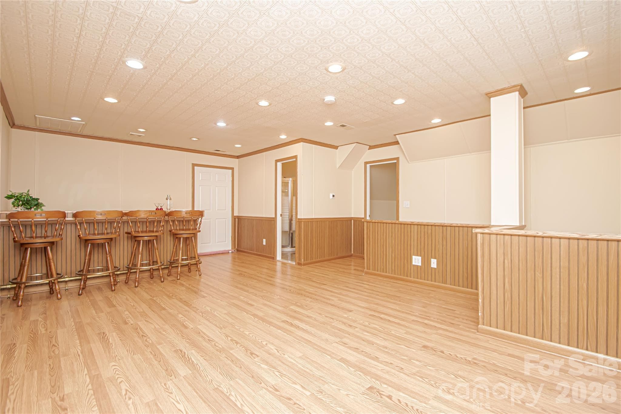 FLEX UPSTAIRS 23'x18': acoustic tile ceiling for the music or game room afficionados. New blinds and Windows 2015, Wainscotting, recess lights, crown molding, Laminate Floors, Insulated door access to walk in attic is right to the bar. - 5480 Glen Forest Drive, Charlotte