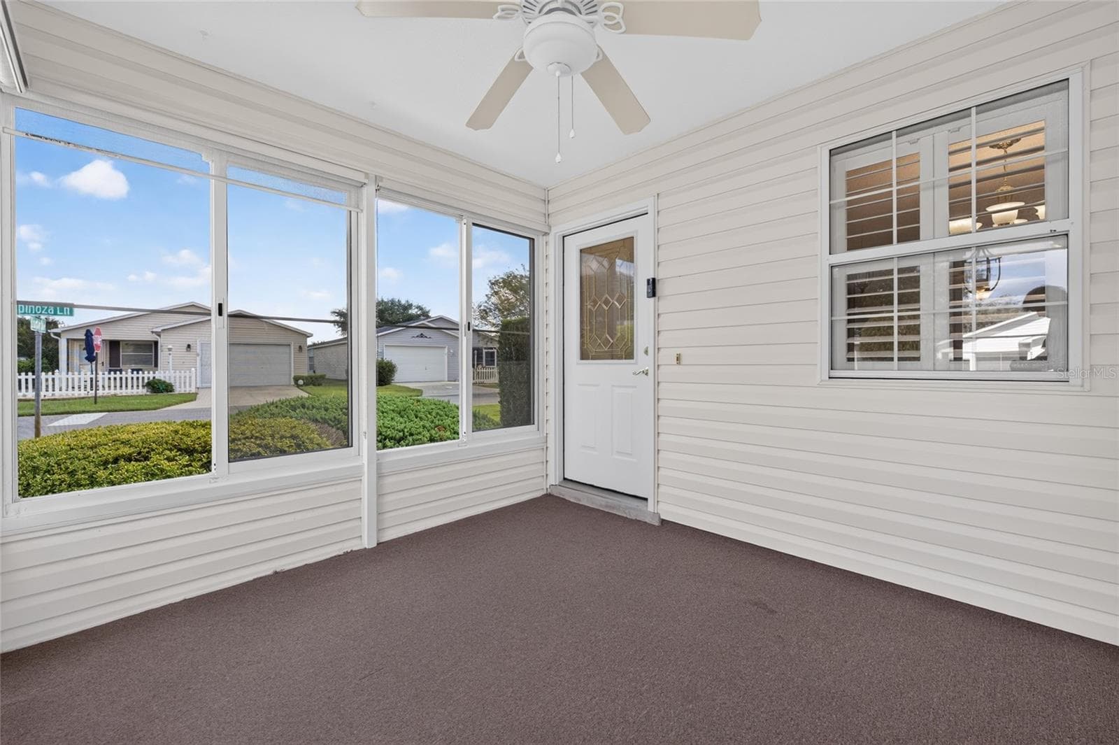 ENCLOSED LANAI / FRONT ENTRY - A half-lite front door with a DECORATIVE LEADED-GLASS INSERT design of geometric shpes, privacy glass & bright brass caming welcomes you into this lovely villa. - 2124 ESCOBAR AVE, THE VILLAGES