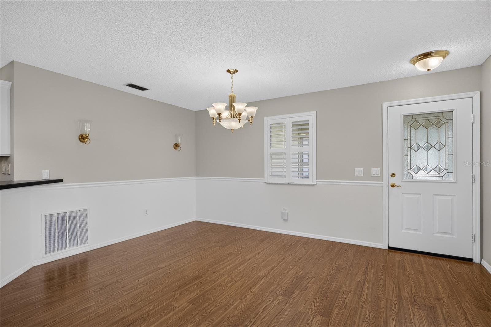 Close up view of DINING AREA - Alternate angle showing the chair rail and back of FRONT DOOR w/ half-lite decorative glass insert. - 2124 ESCOBAR AVE, THE VILLAGES