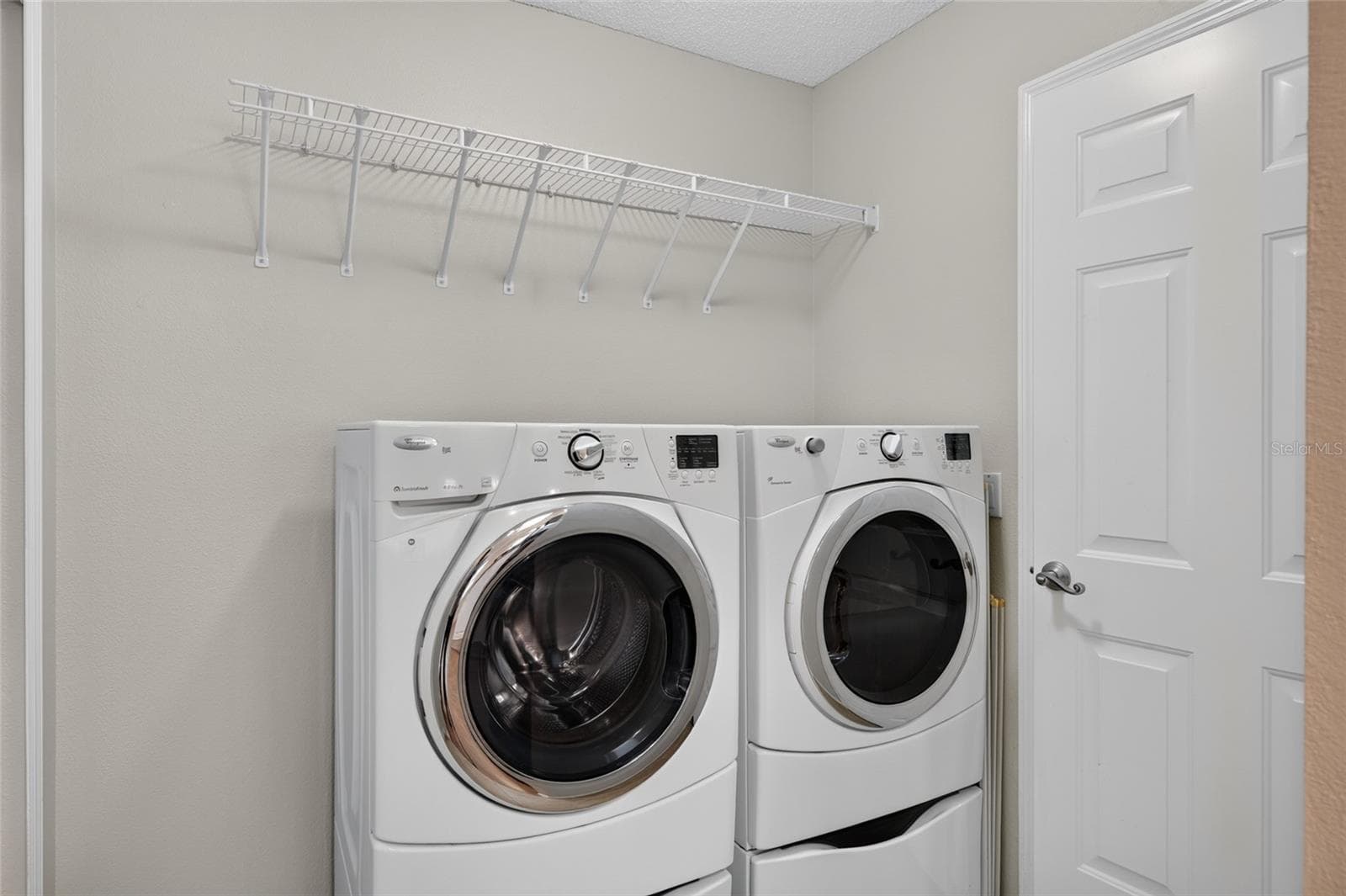 INDOOR LAUNDRY - Adjacent to the kitchen and features a front-load WASHER & DRYER with a storage shelf above the appliances. Note door (R) provides direct access to the 1.5 CAR GARAGE. - 2124 ESCOBAR AVE, THE VILLAGES