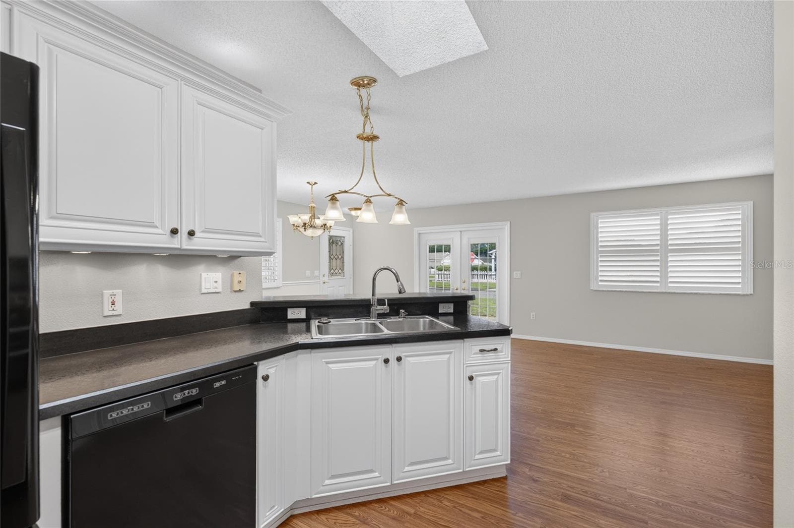 KITCHEN - View of Double sink w/ pull-down faucet (R), FRENCH DOOR REFRIGERATOR (far L) & KitchenAid DISHWASHER (center L). High-definition black laminate countertops round out this efficiently designed triangular workspace. - 2124 ESCOBAR AVE, THE VILLAGES