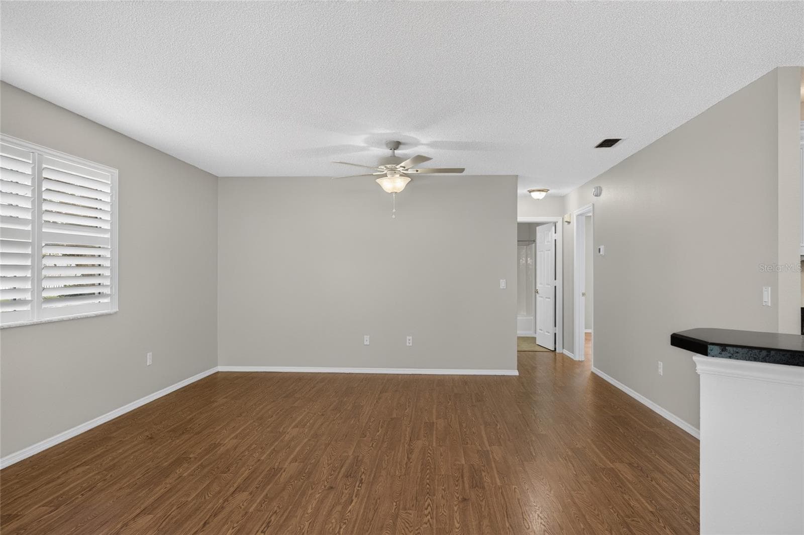 LIVING ROOM / HALLWAY - View from the DINING side looking toward the LR (L), hallway (back R) and adjoining kitchen opening (front R). - 2124 ESCOBAR AVE, THE VILLAGES