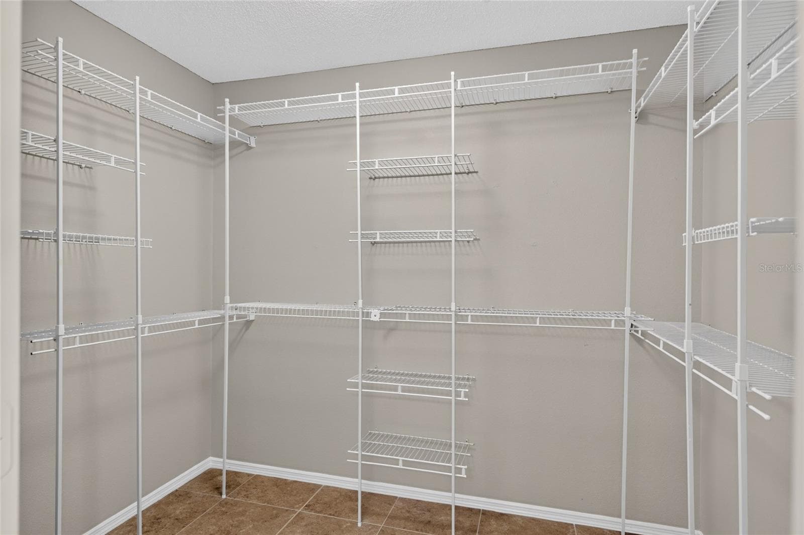 WALK-IN CLOSET - Shelving and hanging rails line multiple walls for generous storage space. - 2124 ESCOBAR AVE, THE VILLAGES