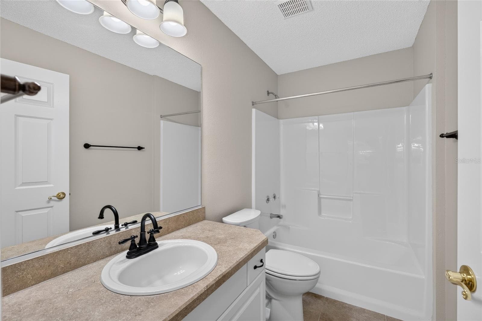 BATHROOM #2 - View of TUB/SHOWER COMBO, comfort-height toilet and single-sink vanity with mirror. - 2124 ESCOBAR AVE, THE VILLAGES