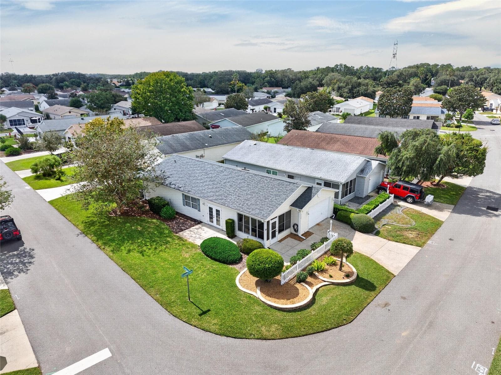 AERIAL VIEW / CORNER LOT - Low aerial view of the villa's CORNER LOT, driveway, front landscaping and adjoining streets. - 2124 ESCOBAR AVE, THE VILLAGES