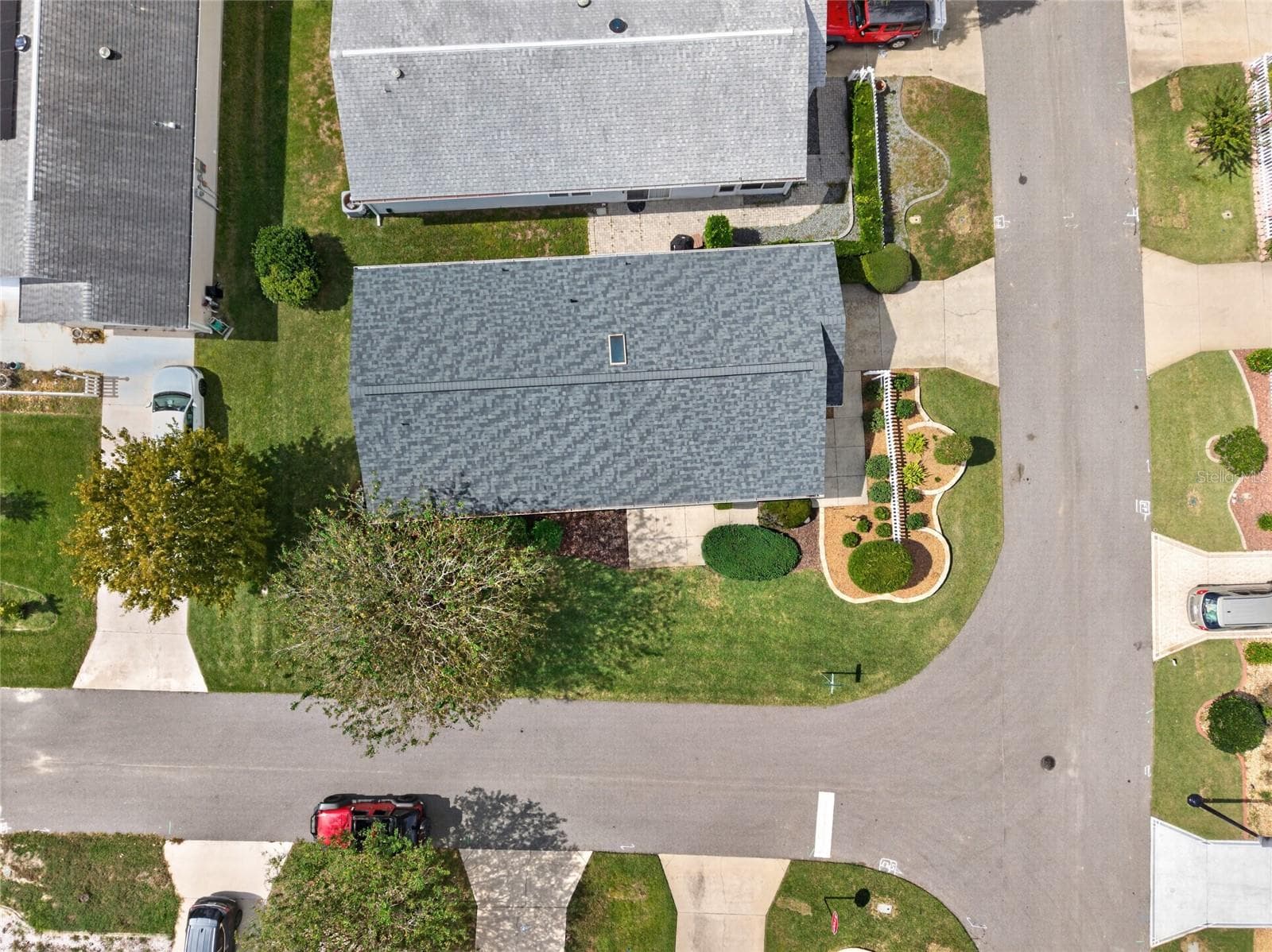 OVERHEAD AERIAL - Top-down view of the ARCH SHINGLE ROOF (2025) and the villa's footprint on a corner lot between the adjoining streets. - 2124 ESCOBAR AVE, THE VILLAGES