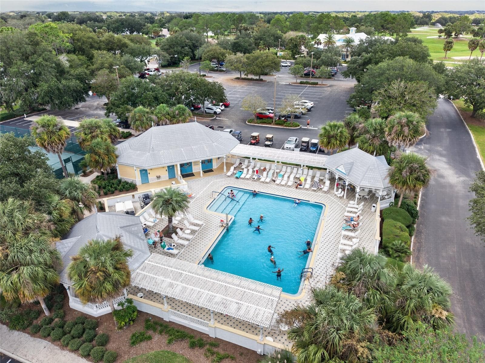 EL SANTIAGO FAMILY POOL - Aerial view of the recreation pool, deck and shaded seating beneath palms. - 2124 ESCOBAR AVE, THE VILLAGES
