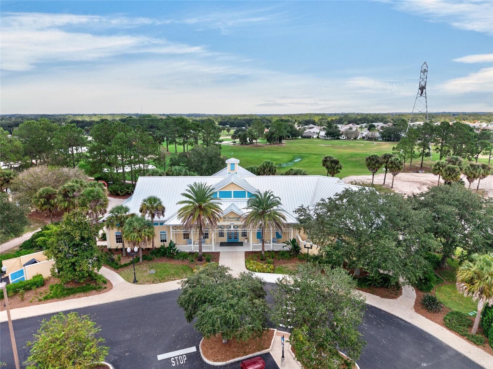 AERIAL VIEW of EL SANTIAGO RECREATION CENTER - Covered entry and parking area, with view of El Diablo executive golf course behind the building. - 2124 ESCOBAR AVE, THE VILLAGES