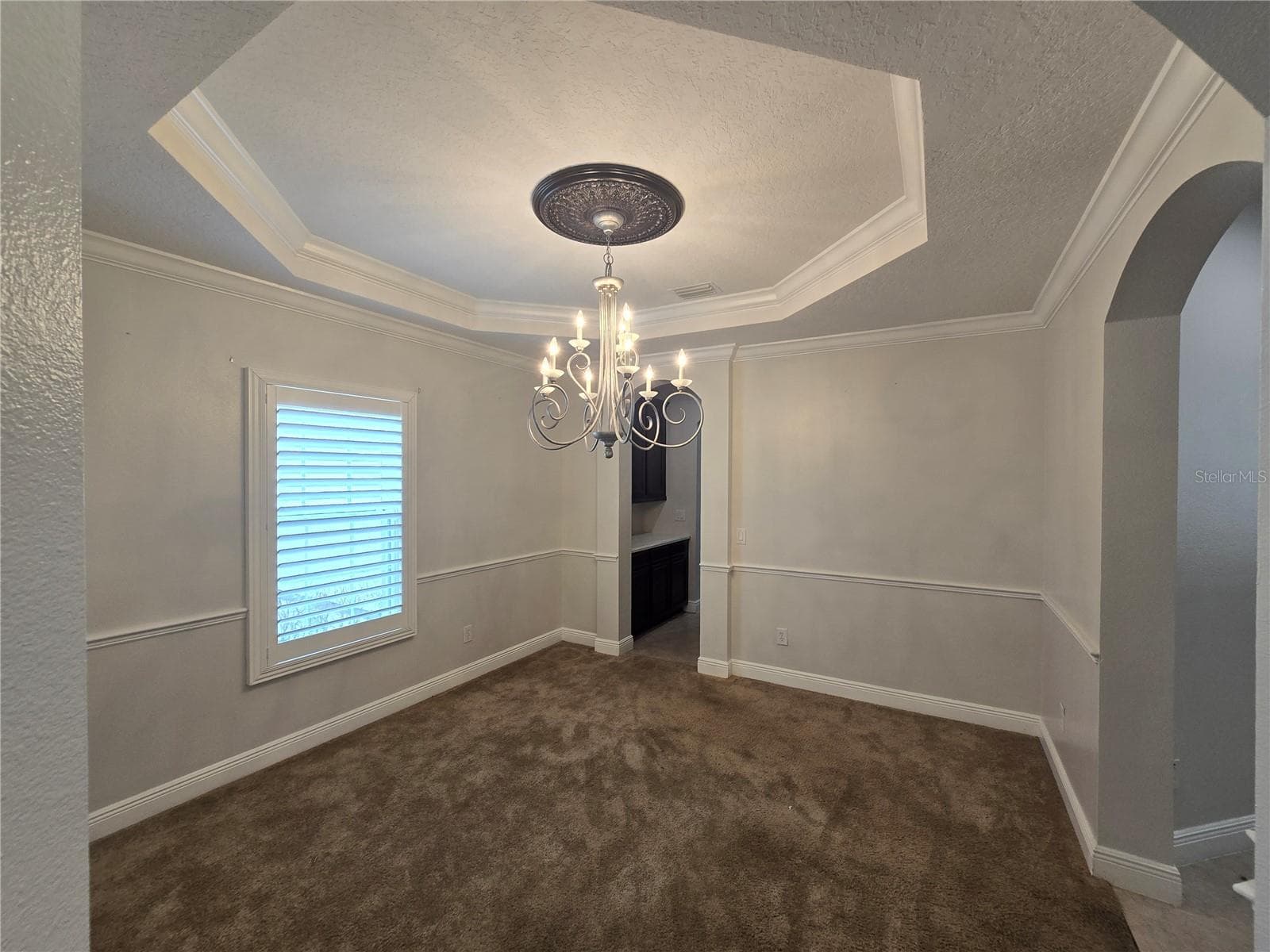 Formal dining area, Butler pantry access to kitchen, tray ceiling, crown molding and chair rail features. - 3405 HEIRLOOM ROSE PL, OVIEDO